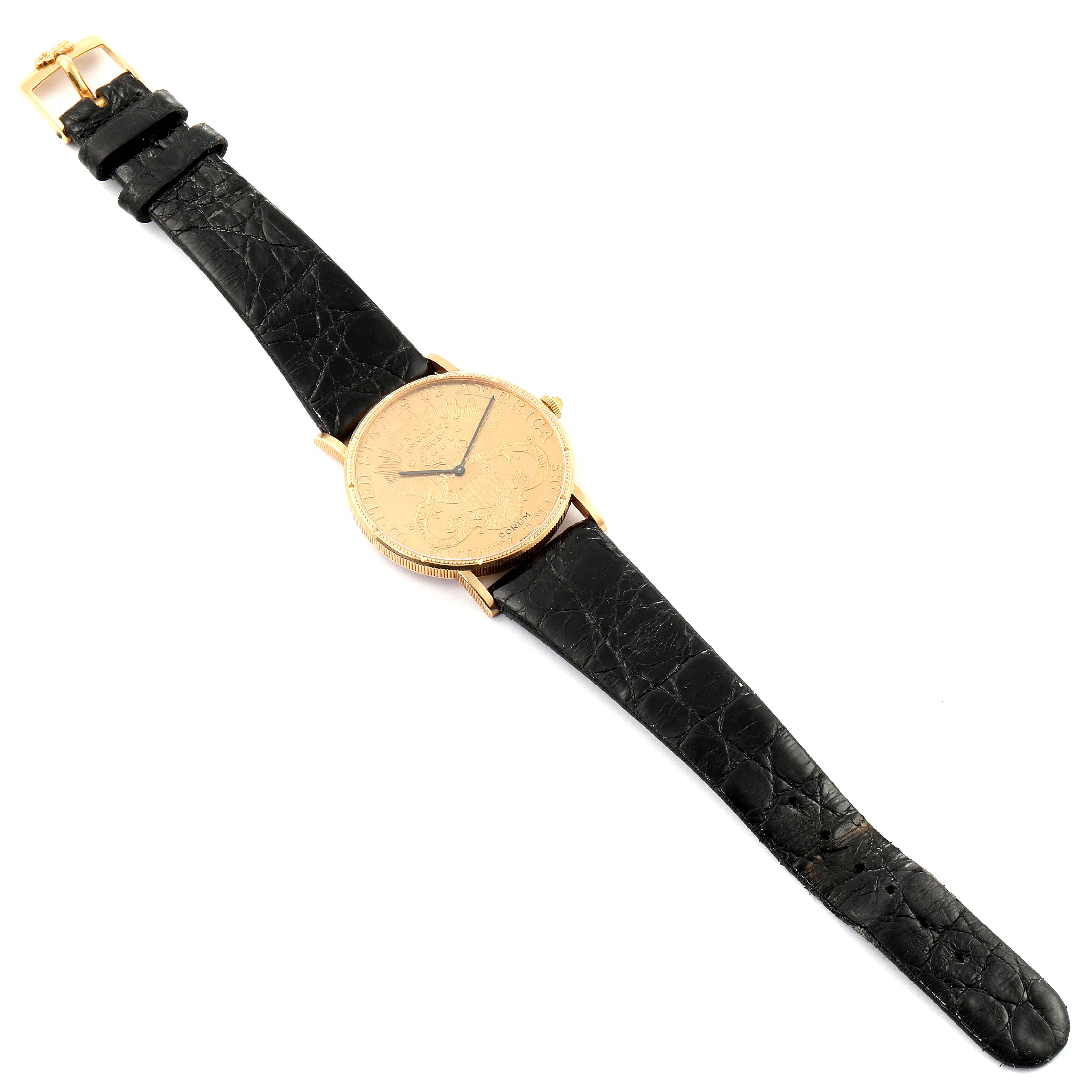 The image shows a Corum Coin Watch 1878 Men's Yellow Gold Black Dial 1878 Men's Yellow Gold Black Dial model from a top-down angle, displaying its black leather strap and engraved gold face.