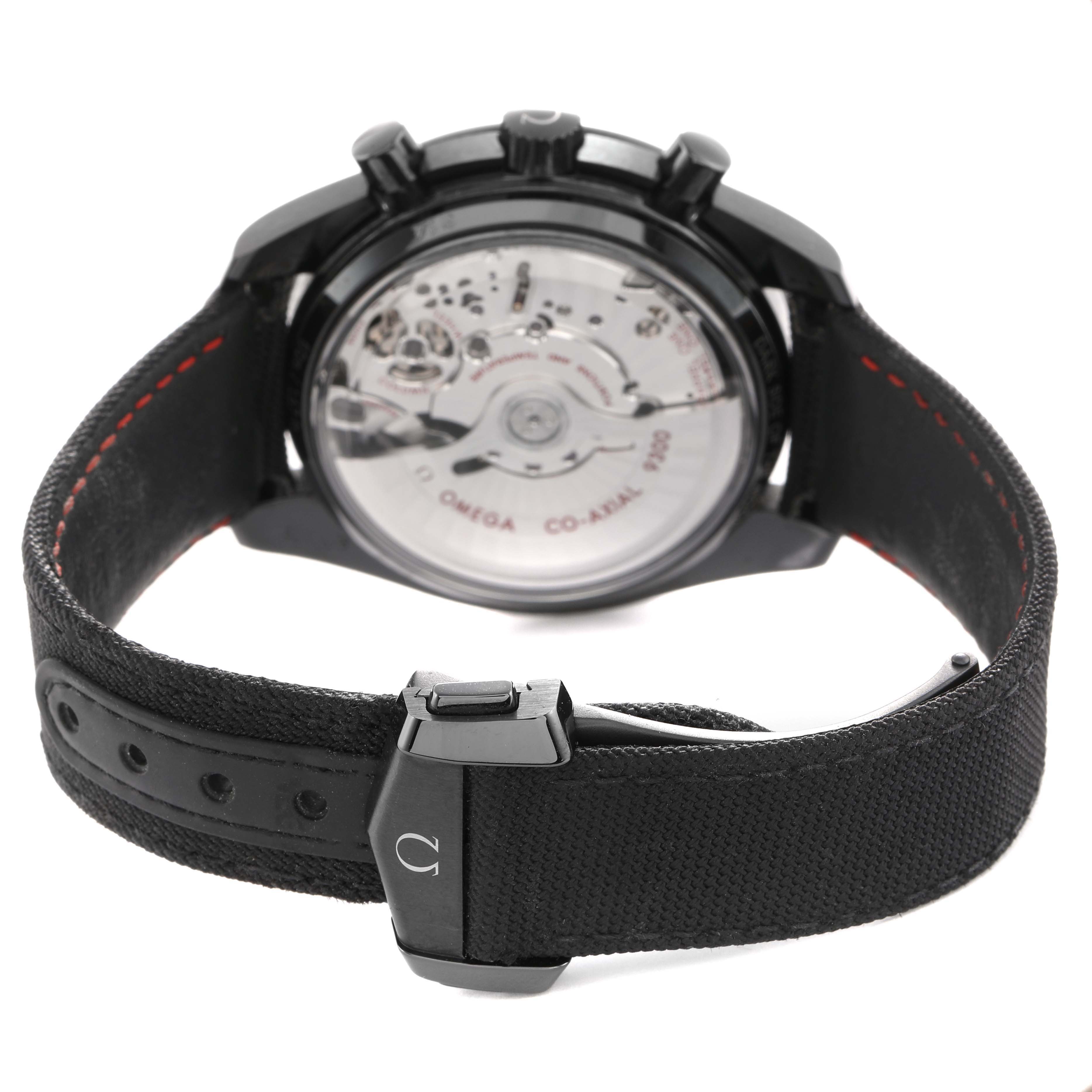 The Omega Speedmaster 311.92.44.51.01.007 Men's Ceramic Black Dial watch is shown from the back, highlighting the transparent case back and strap clasp.