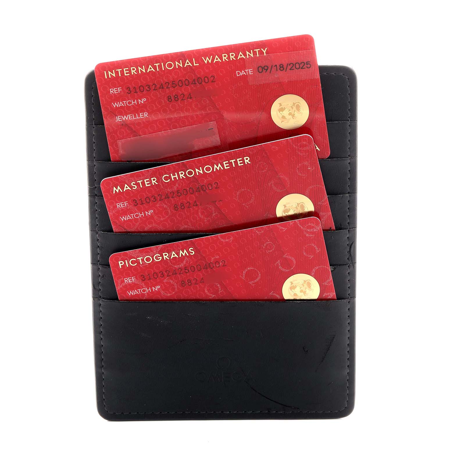 The image shows three red Omega Speedmaster 310.32.42.50.04.002 Men's Stainless Steel White Dial cards for warranty and certification, inserted in a black card holder.