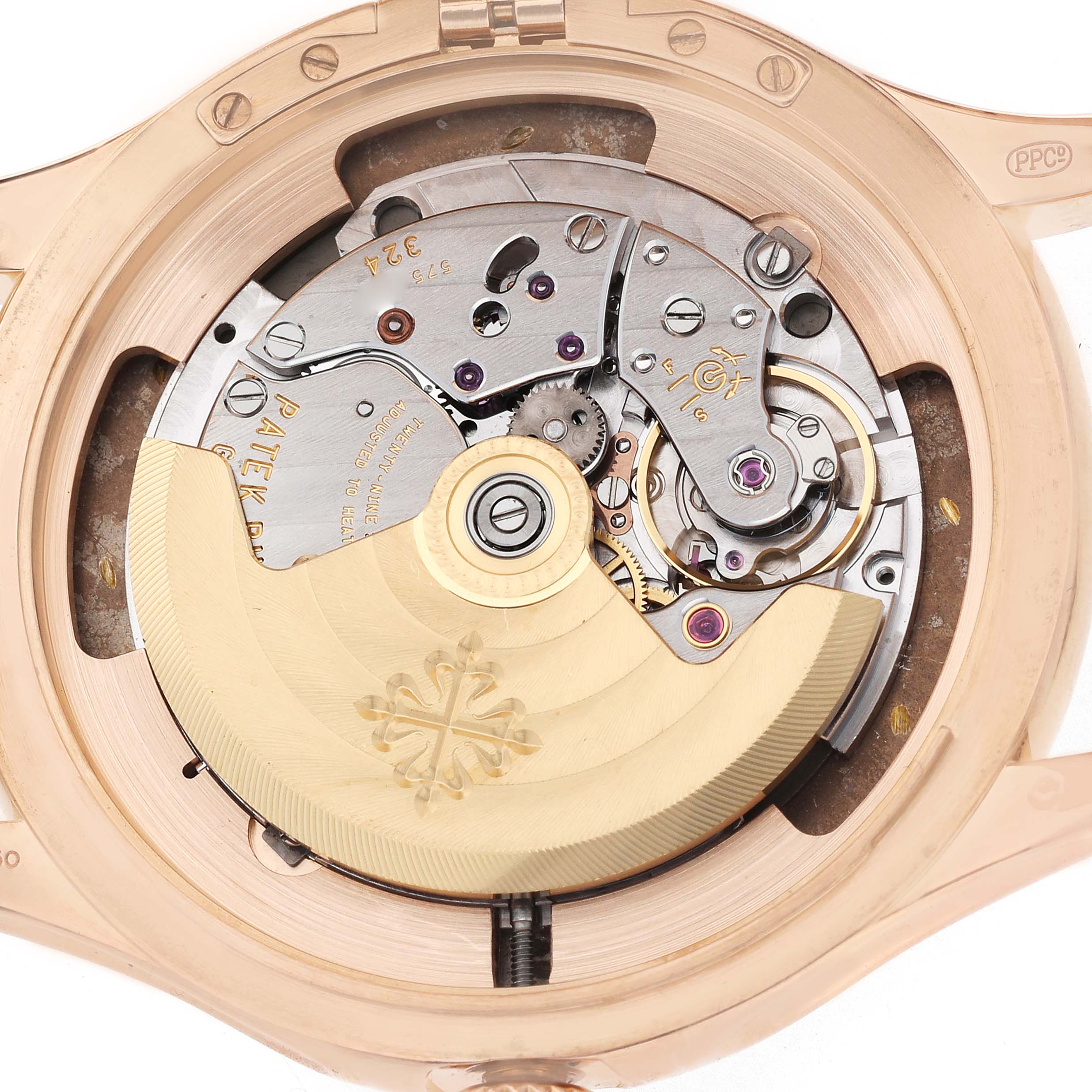 The image shows the movement of a Patek Philippe Calatrava 5227R Men's Rose Gold Beige Dial watch, viewed from the back, featuring its intricate mechanical parts.