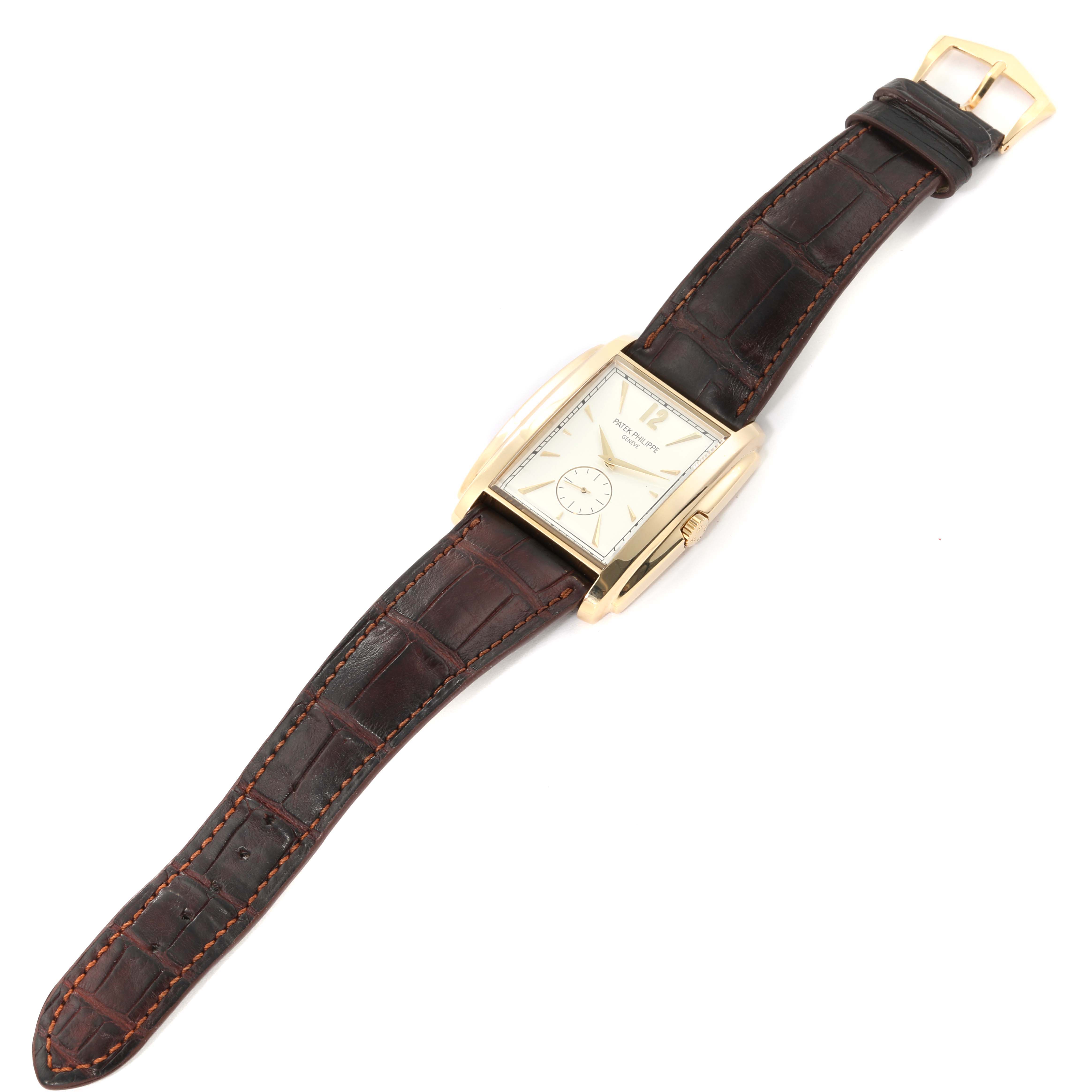 The image shows a top-down view of a Patek Philippe Gondolo 5124J Men's Yellow Gold Silver Dial 5124J Men's Yellow Gold Silver Dial watch, displaying its rectangular face and leather strap.