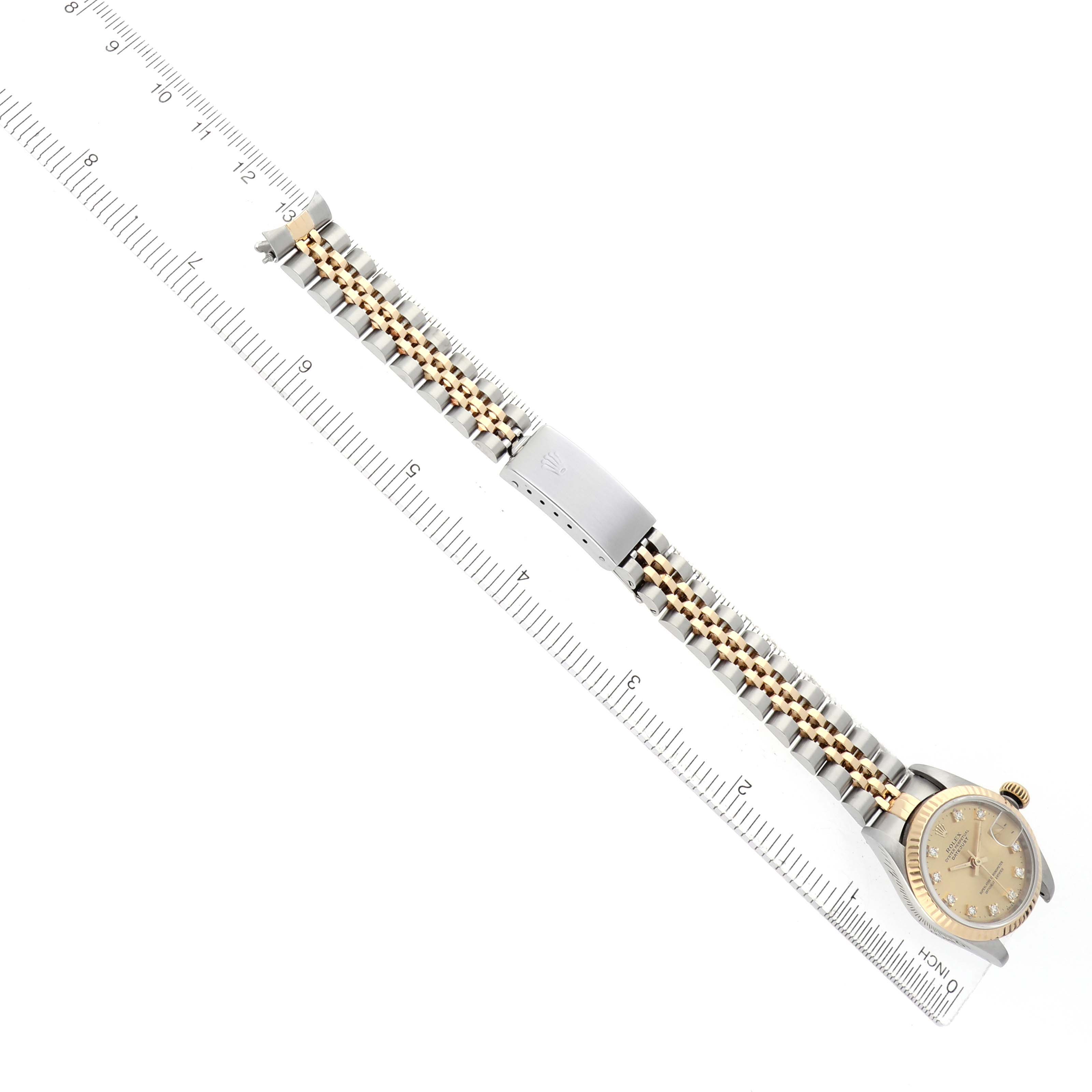 The Rolex Datejust 69173 Women's Steel and Gold (two tone) Champagne Dial watch is shown flat with the full bracelet and clasp visible, alongside a ruler for scale.