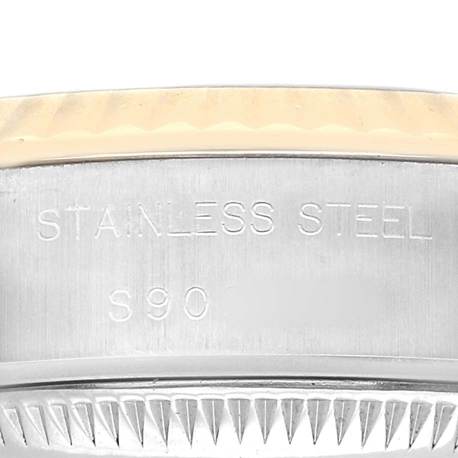 The image shows a close-up of a Rolex Datejust 69173 Women's Steel and Gold (two tone) Champagne Dial watch's stainless steel outer edge, highlighting the engraved text and part of the fluted bezel.