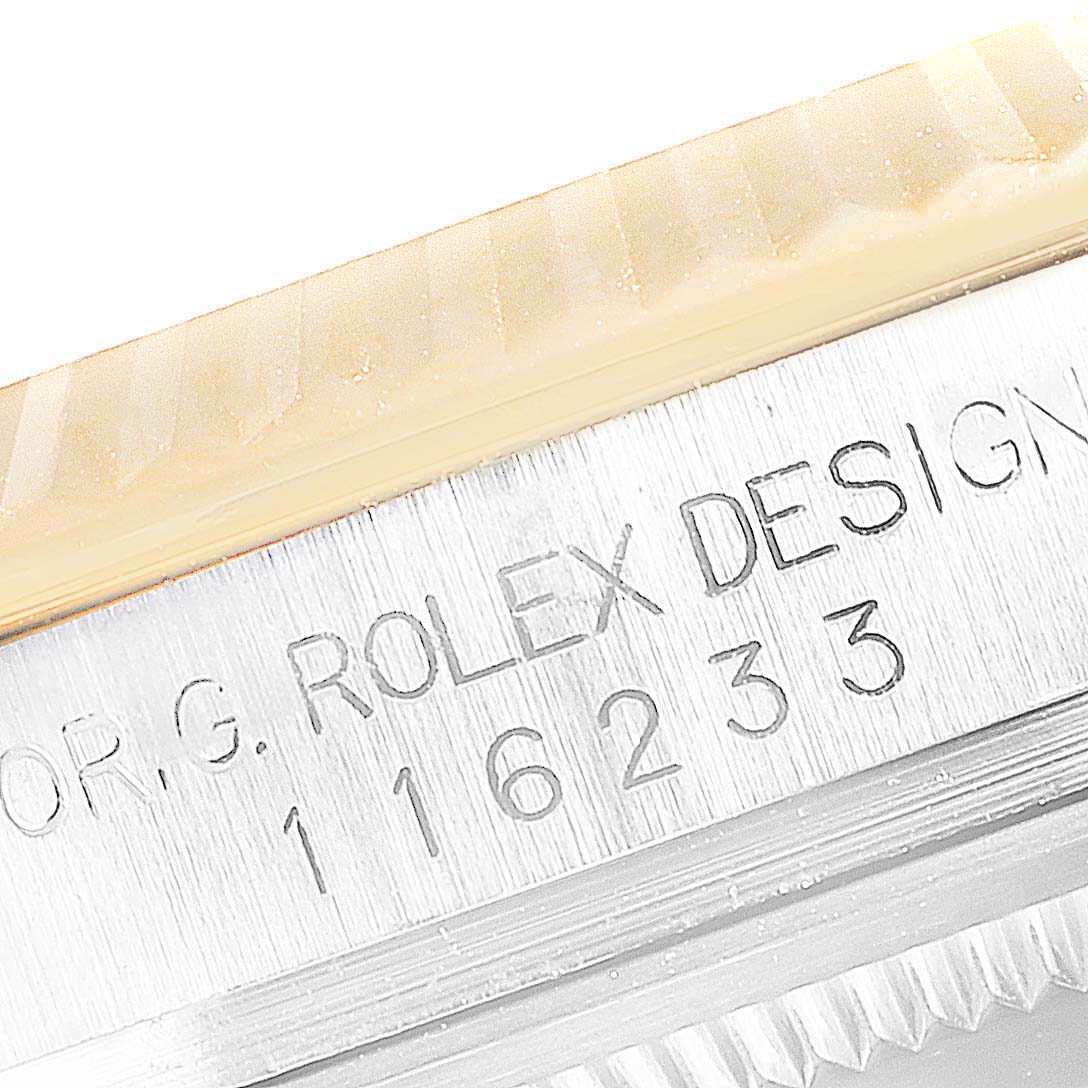 This close-up of a Rolex Datejust 116233 Men's Steel and Gold (two tone) Champagne Dial 116233 Men's Steel and Gold (two tone) Champagne Dial watch shows the engraved serial and reference numbers on the case.