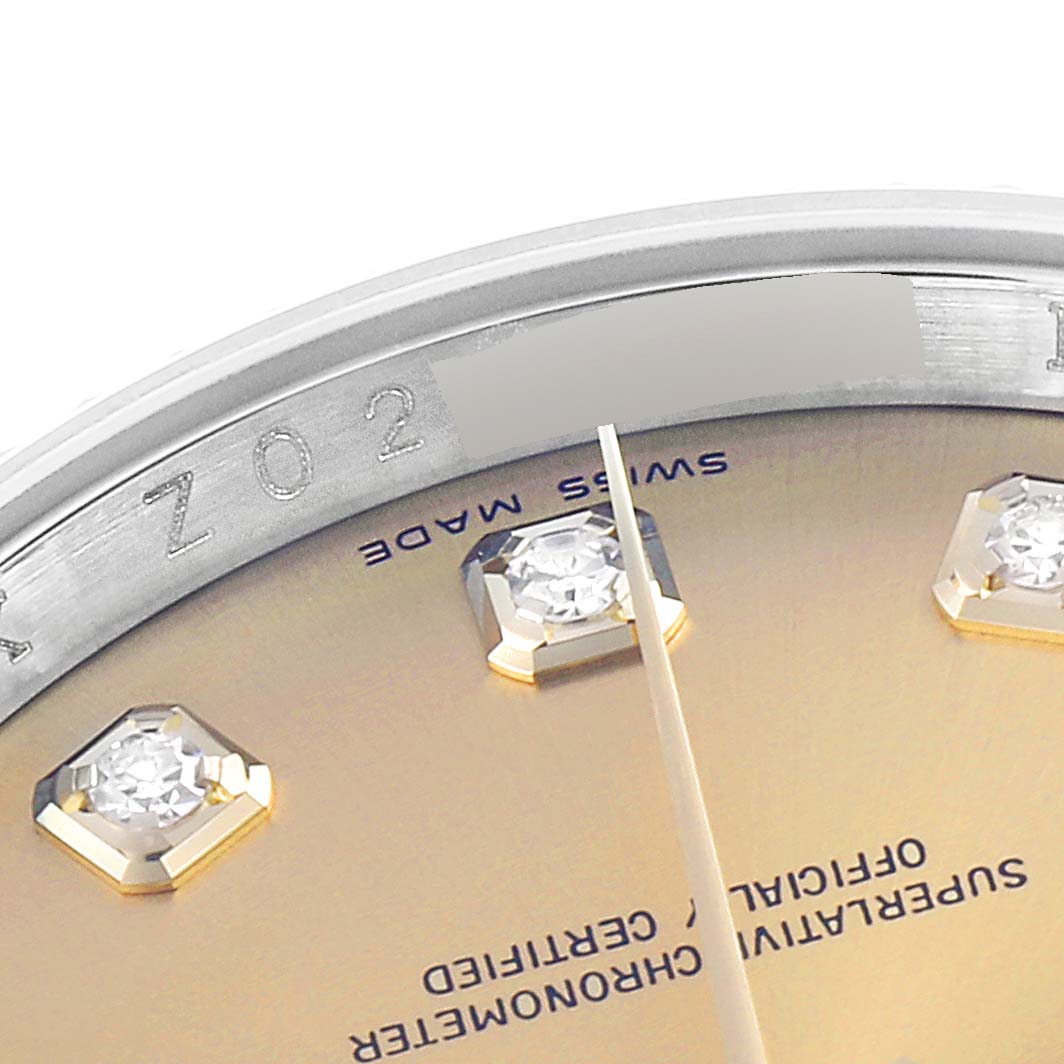 This close-up image shows the dial and part of the bezel of a Rolex Datejust 116233 Men's Steel and Gold (two tone) Champagne Dial 116233 Men's Steel and Gold (two tone) Champagne Dial watch, highlighting the diamonds and inscriptions.