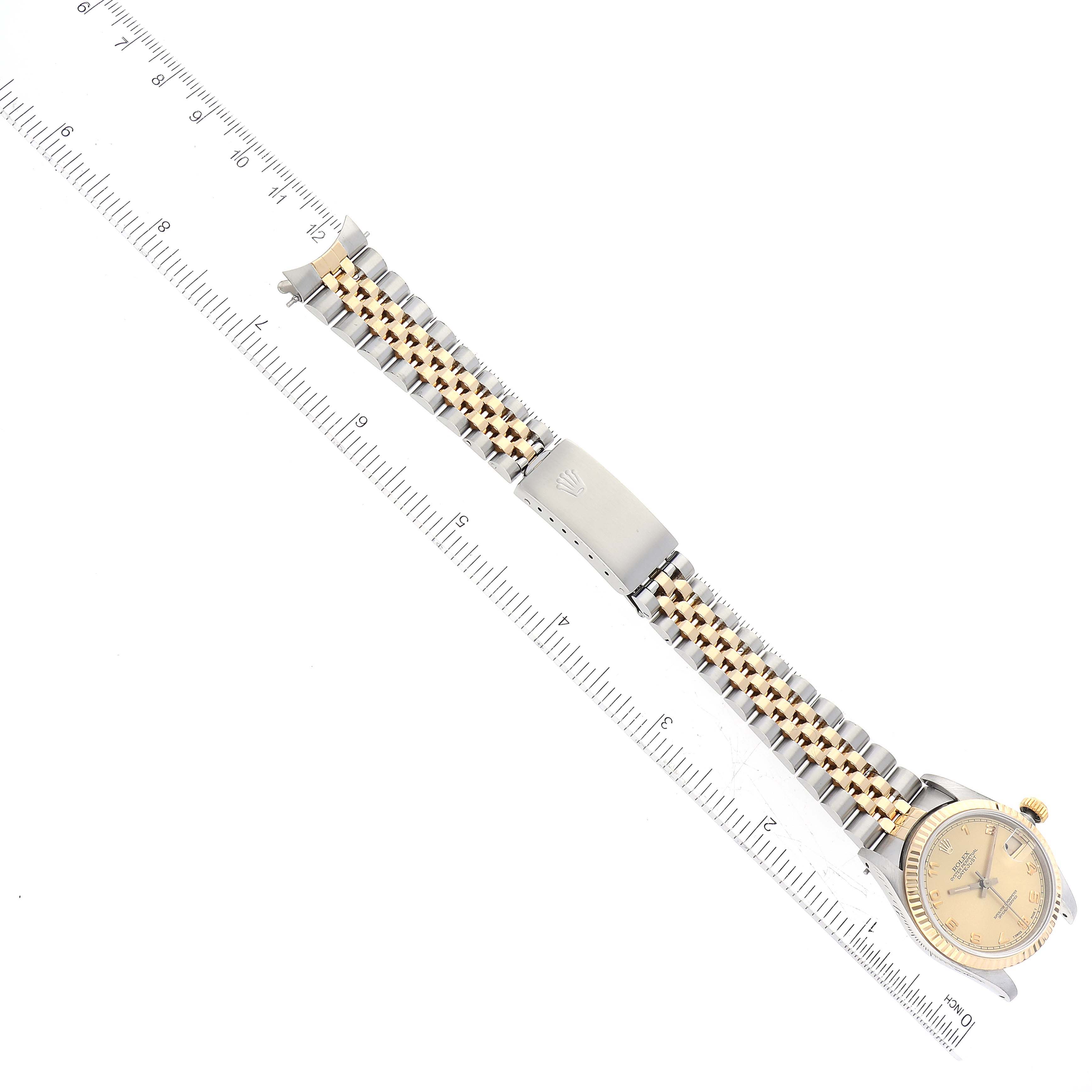 The Mid-Size Rolex watch is shown from a top-down angle, displaying the face, bezel, bracelet, and clasp.