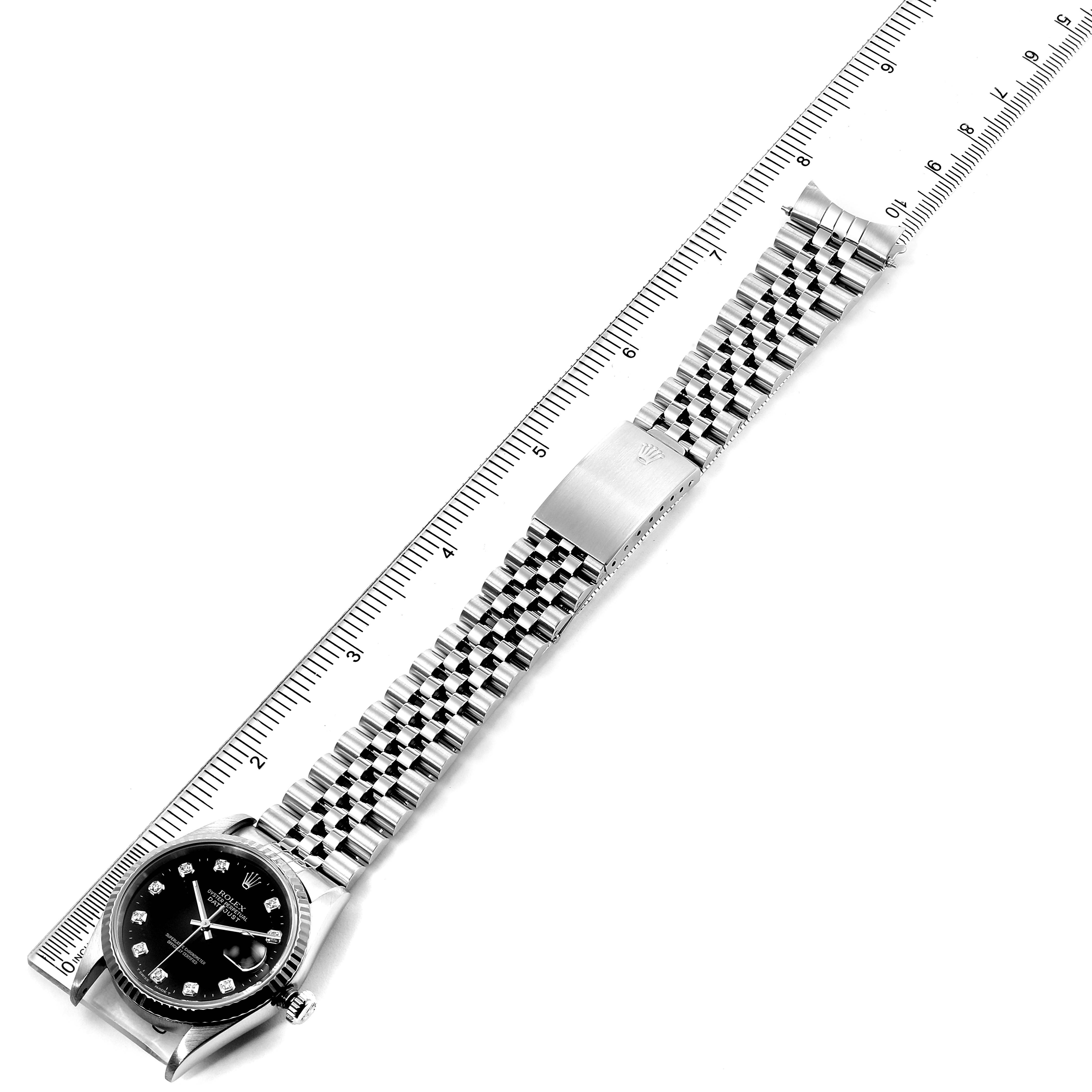 The image shows a Rolex Datejust 16234 Men
s Stainless Steel Black Dial 16234 Men
s Stainless Steel Black Dial watch laid flat with its band extended and aligned next to a ruler for size comparison.