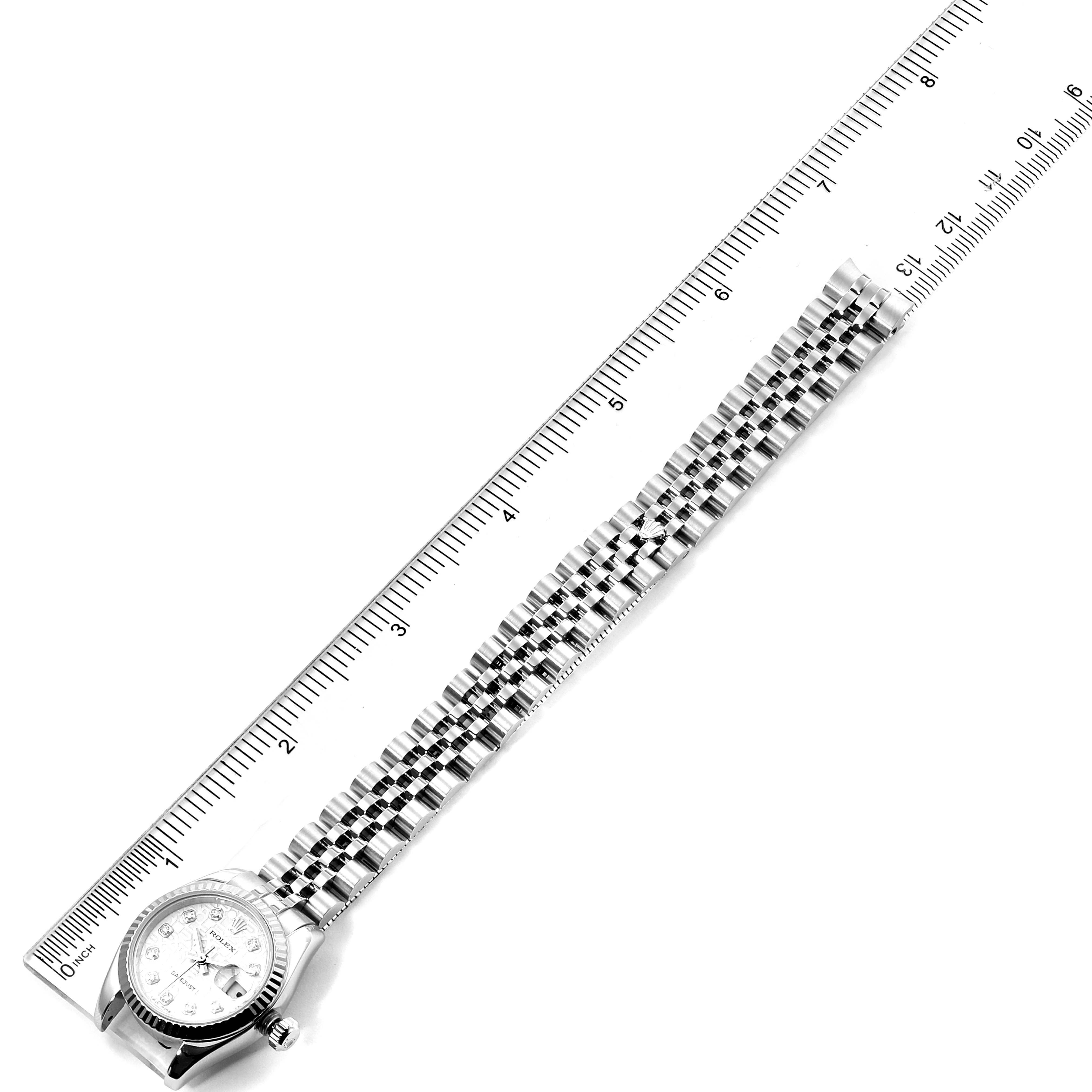The Rolex Datejust 179174 Women's Stainless Steel Silver Dial 179174 Women's Stainless Steel Silver Dial watch is shown from a top-down angle along with a ruler for scale.