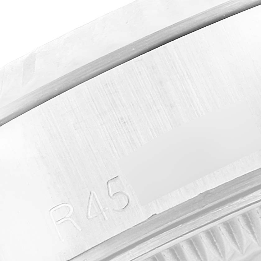 This image shows a macro view of the side of the bezel and part of the case of a Rolex Datejust 69174 Women's Stainless Steel Silver Dial 69174 Women's Stainless Steel Silver Dial watch.