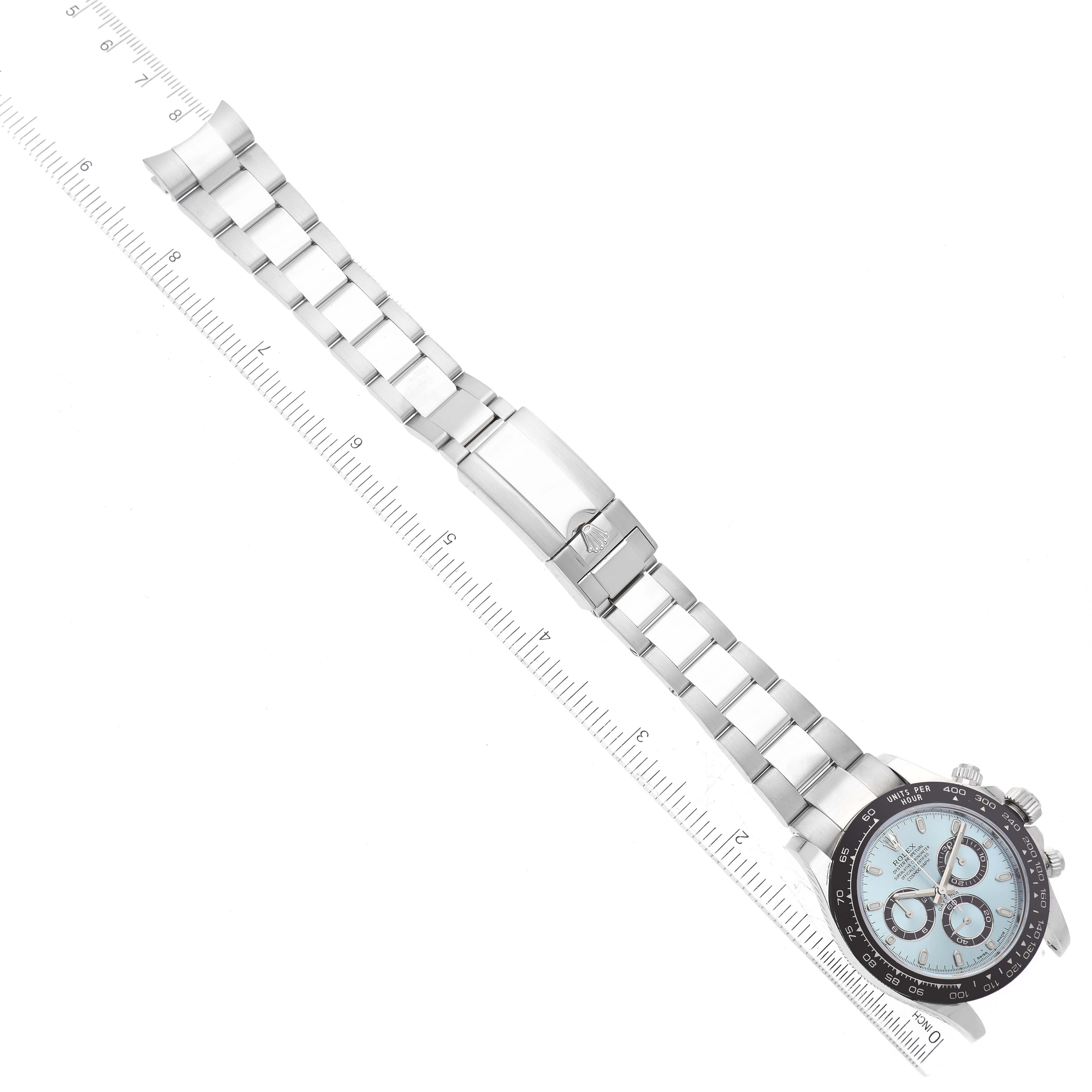 The image shows a Rolex Daytona 116506 Men's Platinum Blue Dial 116506 Men's Platinum Blue Dial watch laid flat with a ruler parallel to its wristband, displaying the bracelet, dial, and clasp.