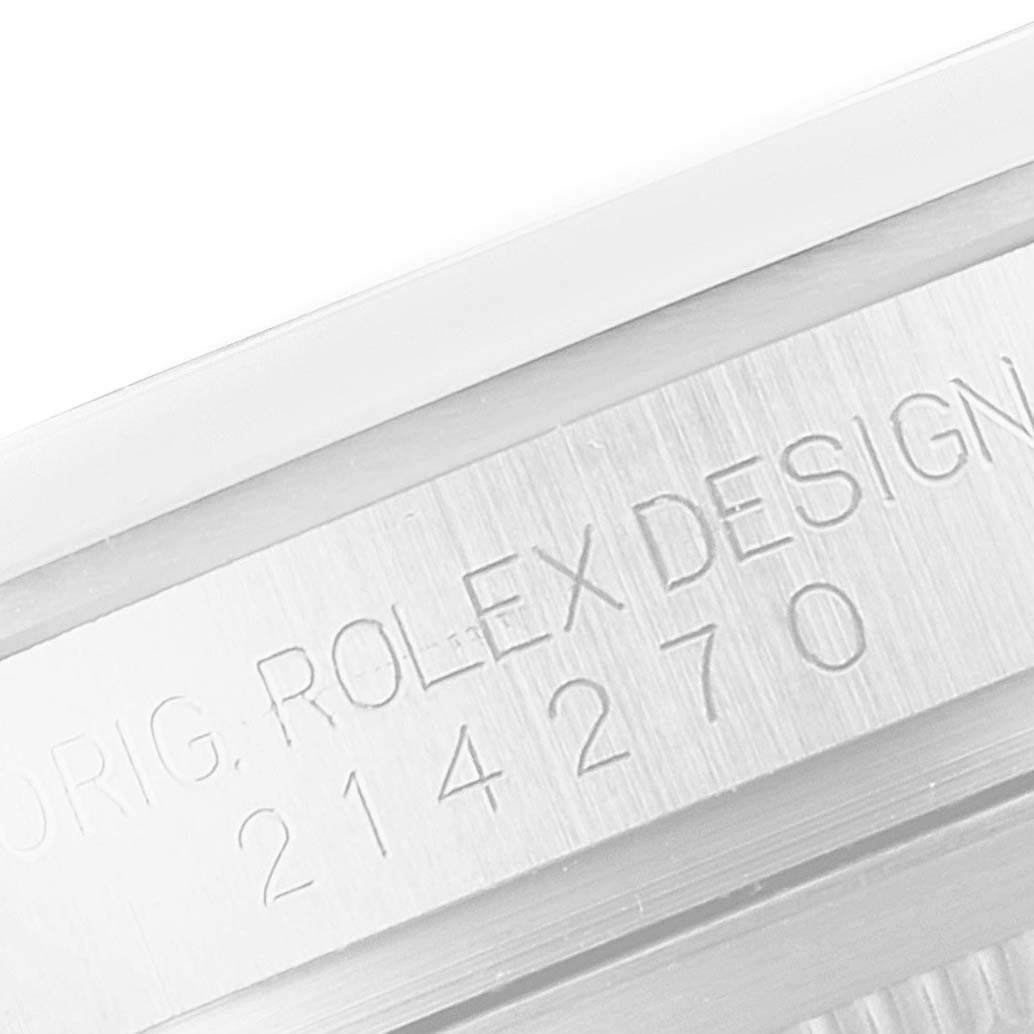 The image shows a close-up of the case edge of a Rolex Explorer 214270 Men
s Stainless Steel Black Dial 214270 Men
s Stainless Steel Black Dial watch, displaying its model number and "Rolex Design" engraving.