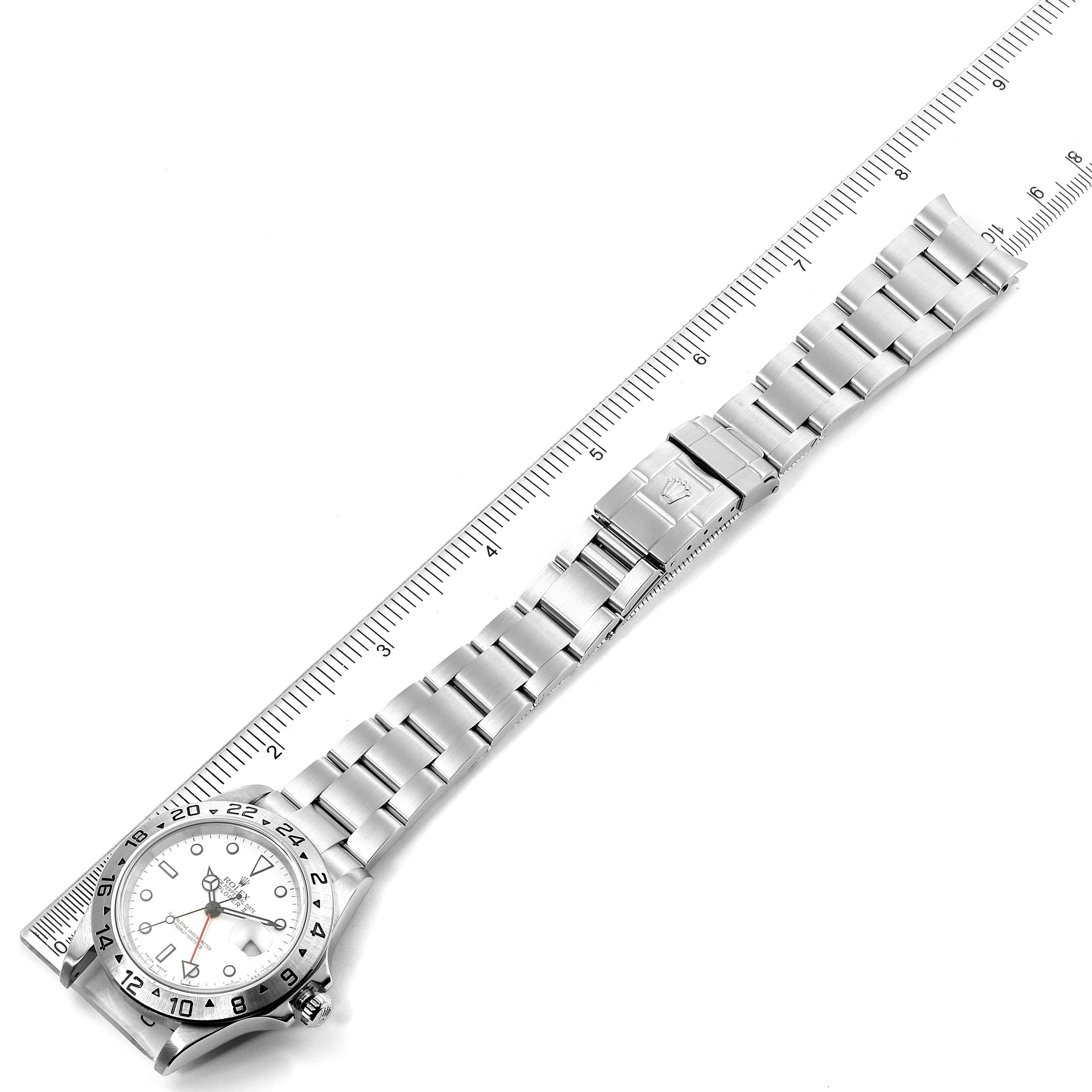 The image shows a top-down view of a Rolex Explorer 16570 Men
s Stainless Steel White Dial 16570 Men
s Stainless Steel White Dial watch, displaying the watch face, bezel, and bracelet alongside a ruler.