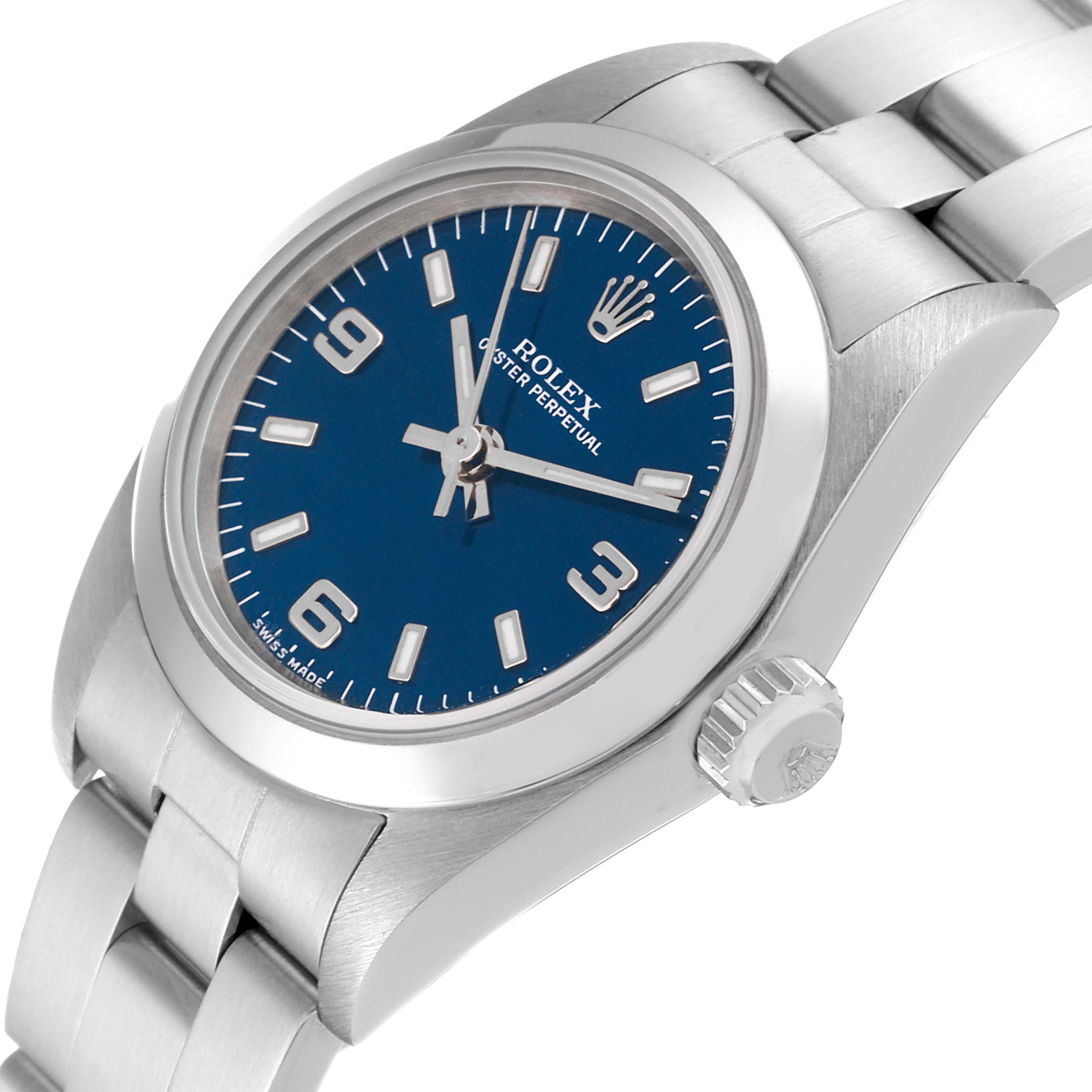 The Rolex Oyster Perpetual 76080 Women
s Stainless Steel Blue Dial 76080 Women
s Stainless Steel Blue Dial watch is shown at a three-quarter angle, highlighting its blue dial, crown, and stainless steel bracelet.