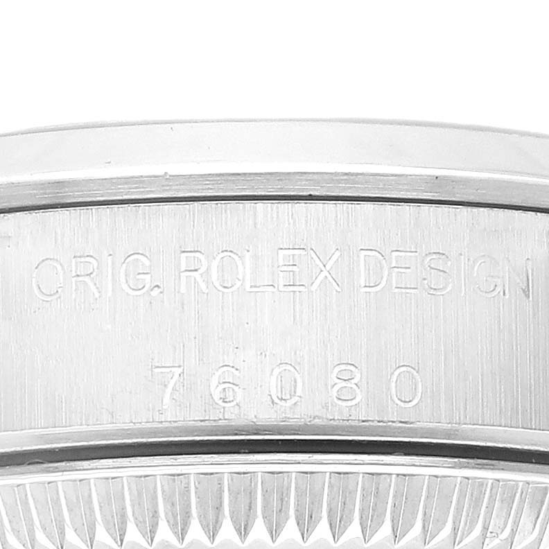 The image shows an up-close view of the engraved design and model number on the case side of a Rolex Oyster Perpetual 76080 Women
s Stainless Steel Blue Dial 76080 Women
s Stainless Steel Blue Dial watch.
