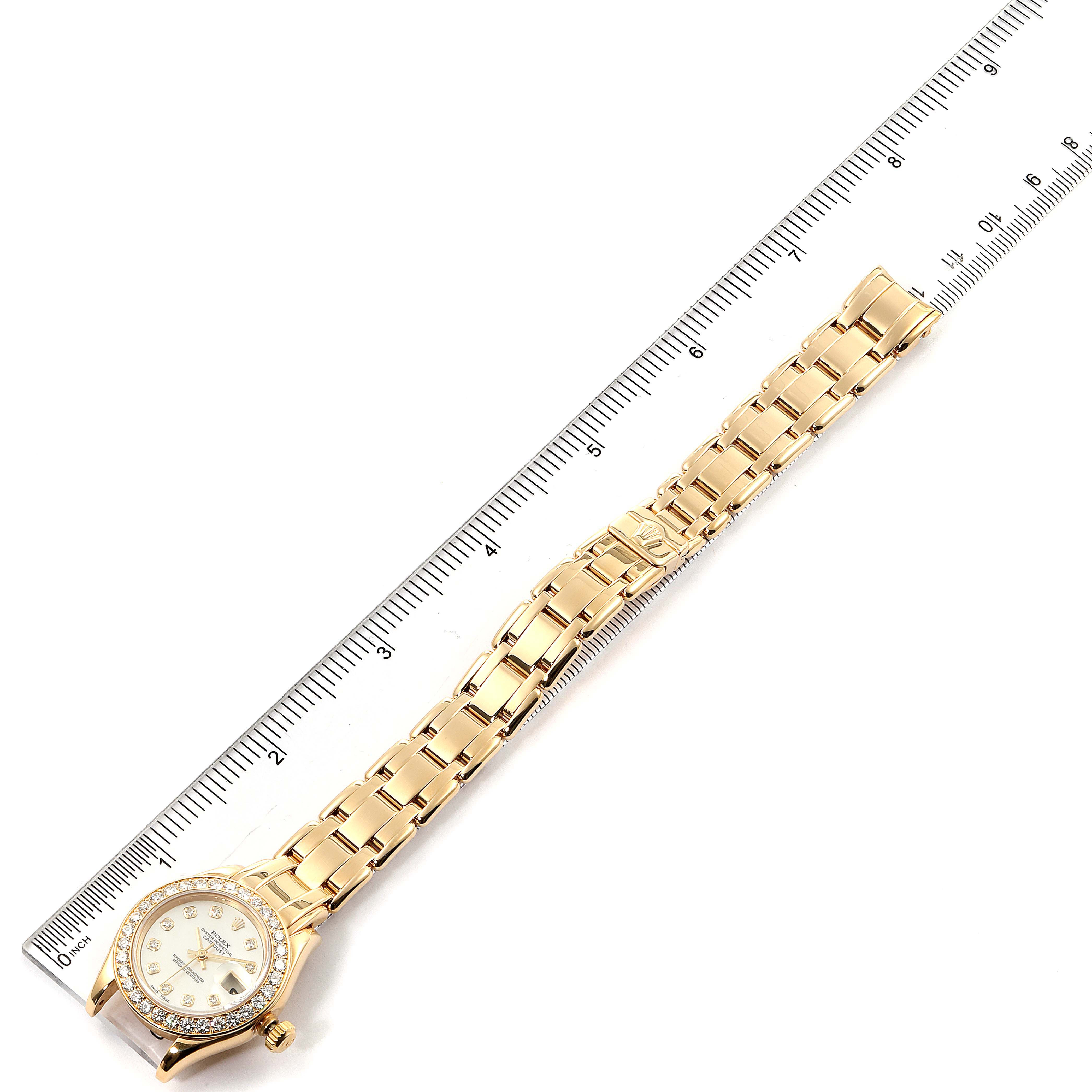 The image shows a Rolex Pearlmaster 69298 Women's Yellow Gold Mother of Pearl Dial 69298 Women's Yellow Gold Mother of Pearl Dial watch laid flat with a ruler for scale, highlighting the face and band.