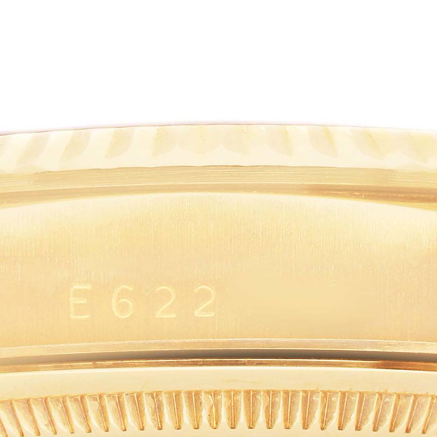 The image shows a close-up of the Rolex President 18238 Men's Yellow Gold Champagne Dial model's gold bezel and engraved serial number, viewed from the side.