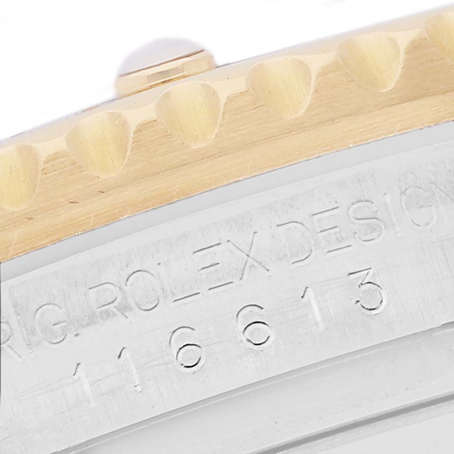 The image shows a close-up of the bezel and part of the engraved case of a Rolex Submariner 116613 Men's Steel and Gold (two tone) Black Dial watch.