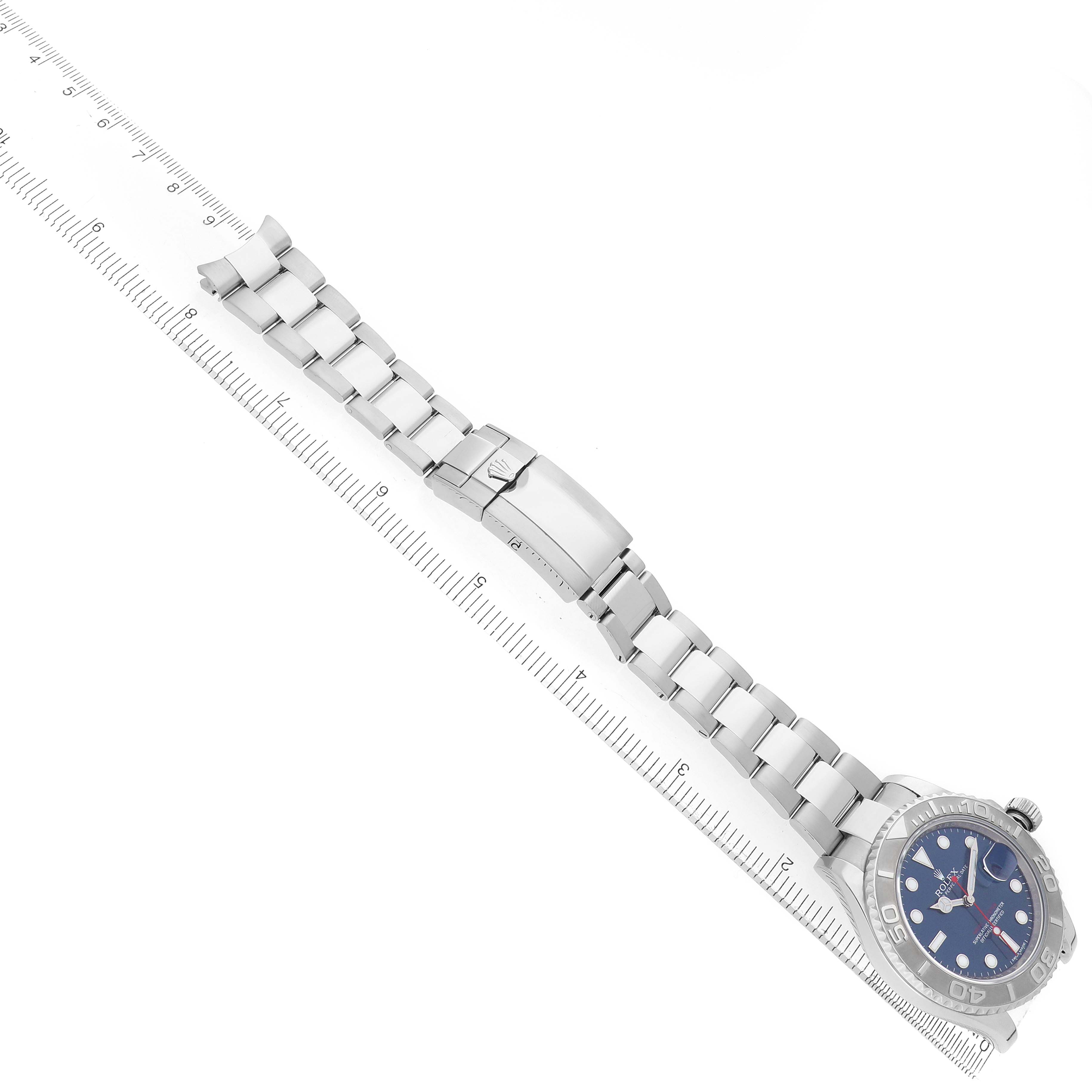 The Rolex Yacht-Master 116622 Men's Stainless Steel Blue Dial watch is shown from an overhead angle, displaying its full bracelet and clasp alongside a ruler.
