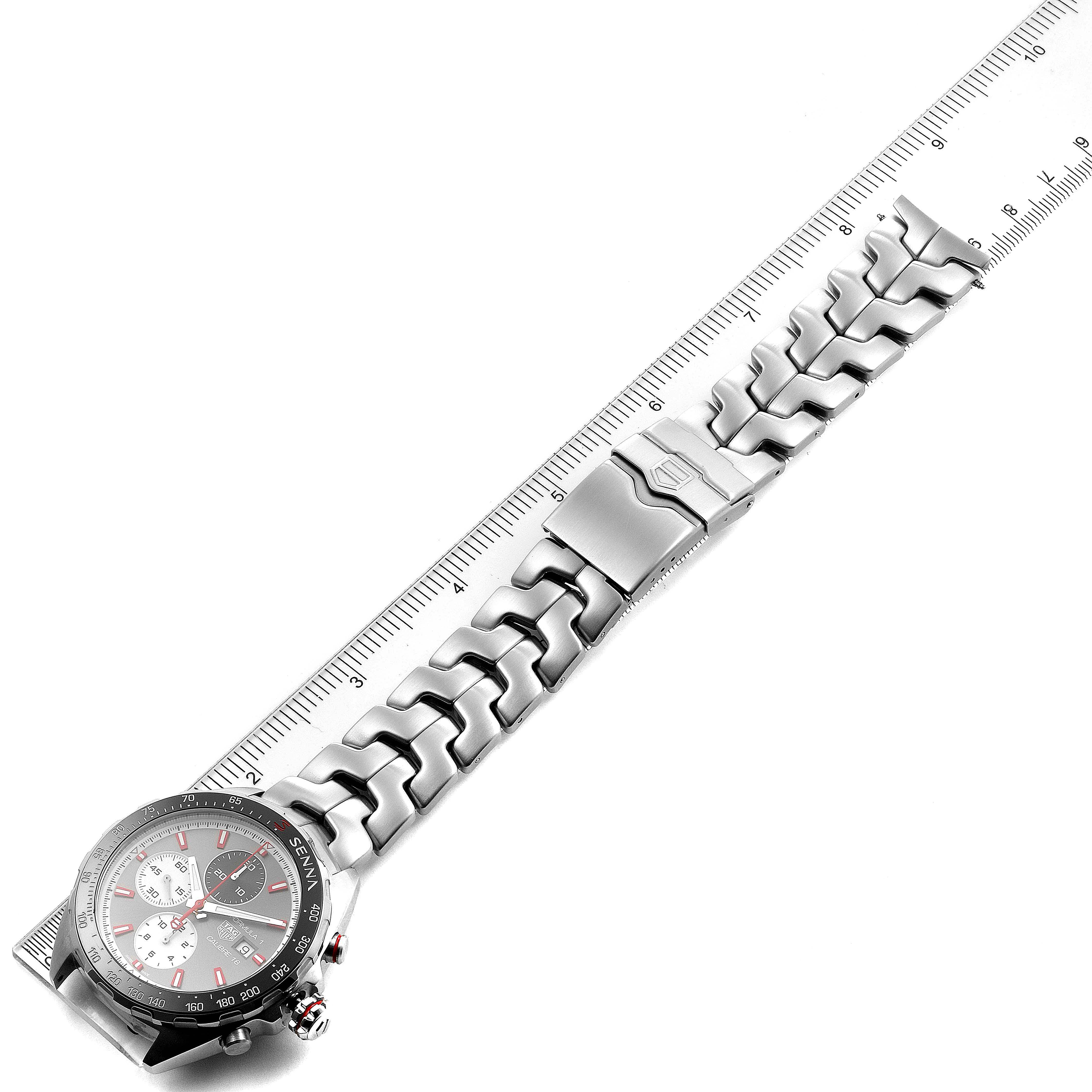 The Tag Heuer Formula 1 CAZ2017.BA0647 Men's Stainless Steel Grey Dial CAZ2017.BA0647 Men's Stainless Steel Grey Dial model watch is shown from a top-down angle, displaying the face, bezel, bracelet, and clasp alongside a ruler.