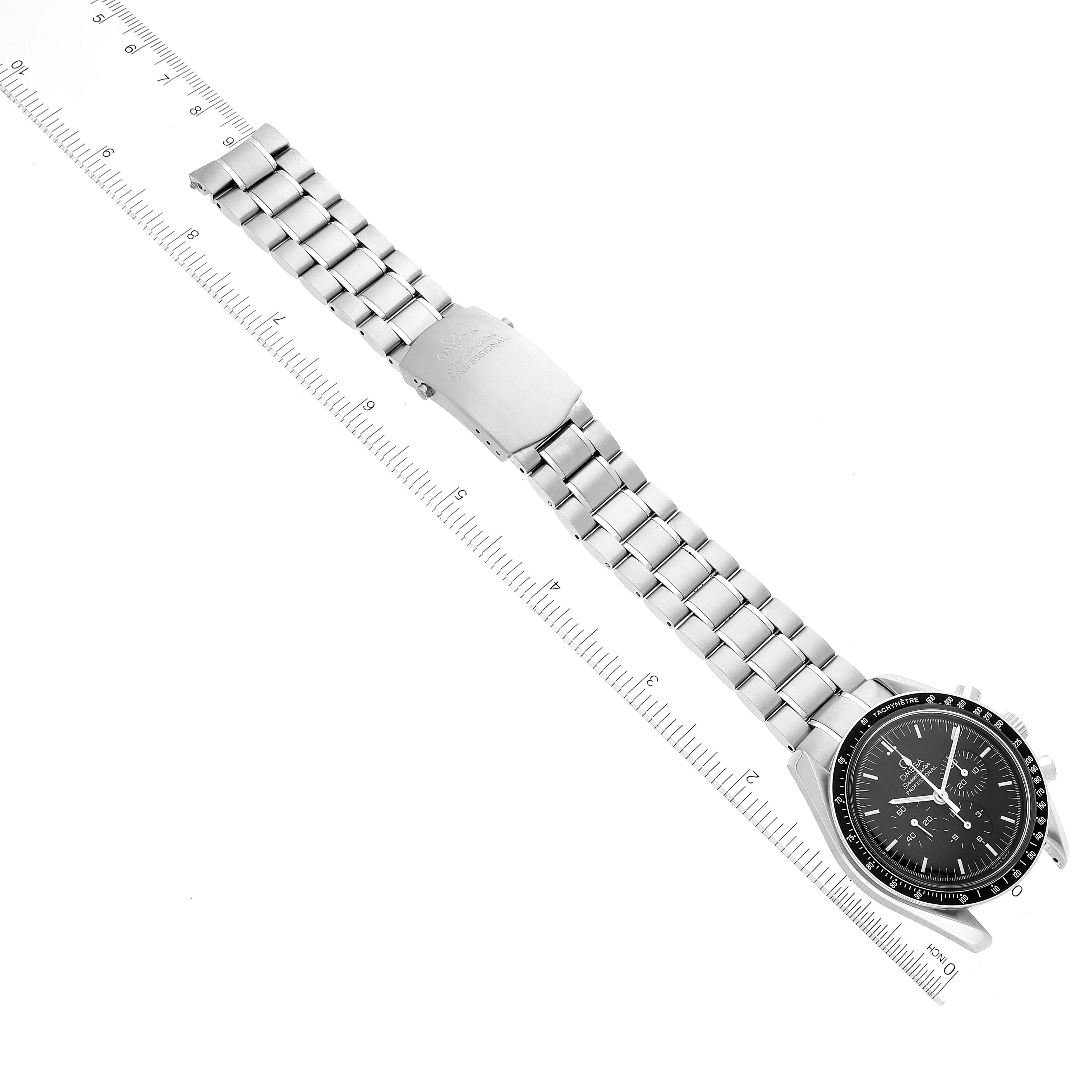 The image shows the Omega Speedmaster 3570.50.00 Men's Stainless Steel Black Dial 3570.50.00 Men's Stainless Steel Black Dial watch laid flat, prominently displaying the bracelet and clasp next to a ruler for scale.