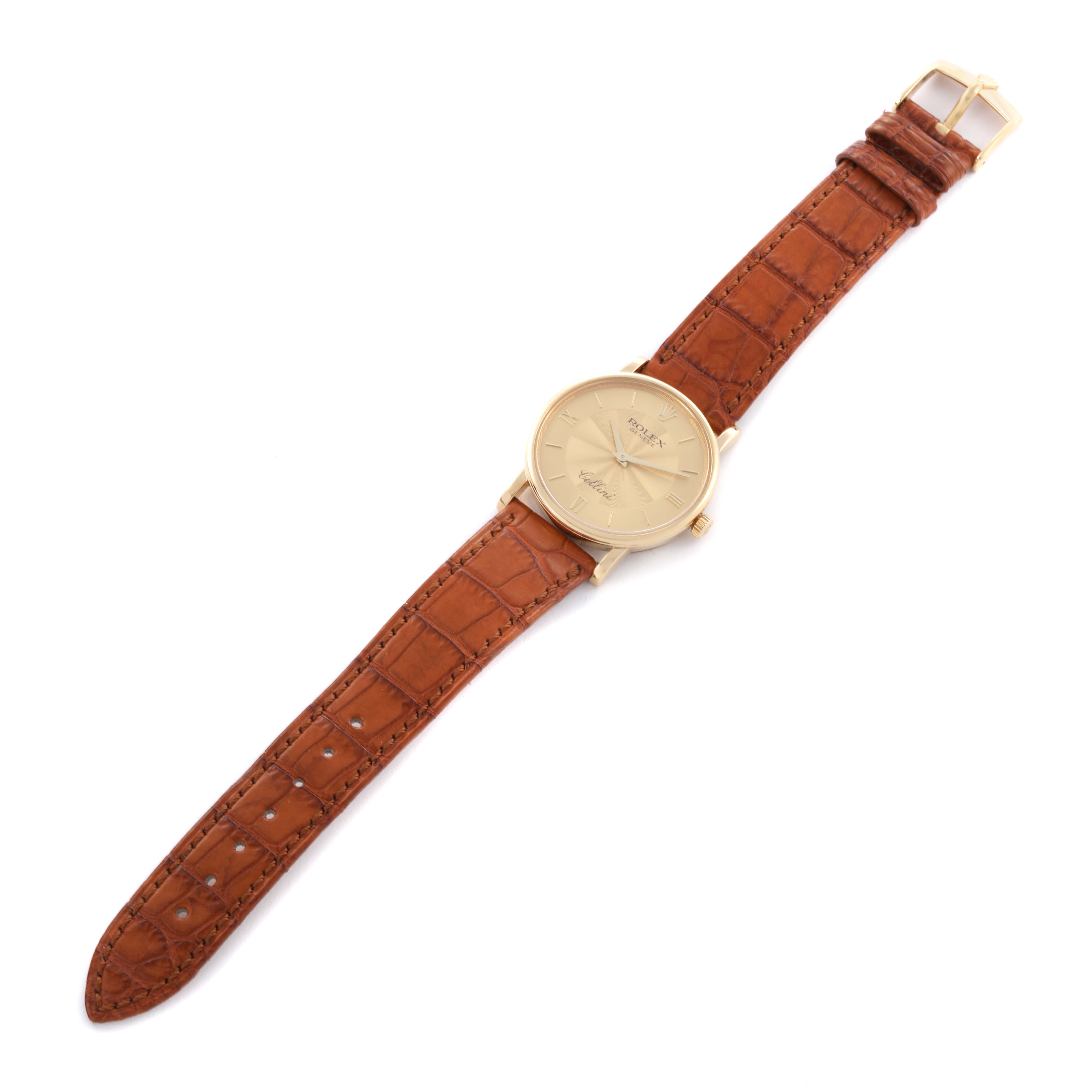 The Rolex Cellini 5115 Men's Yellow Gold Champagne Dial 5115 Men's Yellow Gold Champagne Dial watch is shown from a top-down angle, displaying the face, case, and brown leather strap.