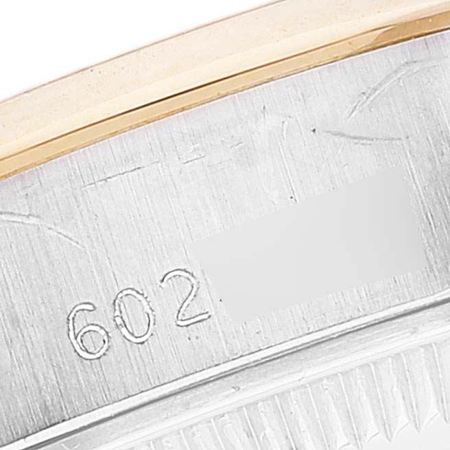 A close-up of the engravings on the casing of a Rolex Date 6916 Women's Steel and Gold (two tone) White Dial 6916 Women's Steel and Gold (two tone) White Dial model watch, showing its reference number and part of the bezel.