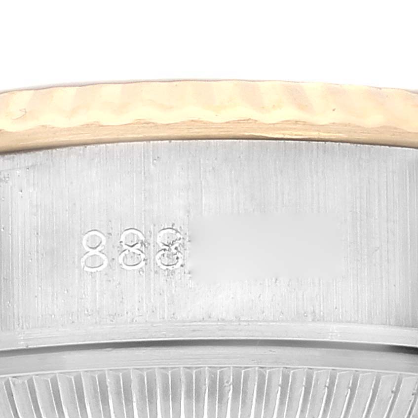 This is a close-up view of a Rolex Datejust 69173 Women's Steel and Gold (two tone) White Dial 69173 Women's Steel and Gold (two tone) White Dial watch, showing part of the bezel and serial number engraving.