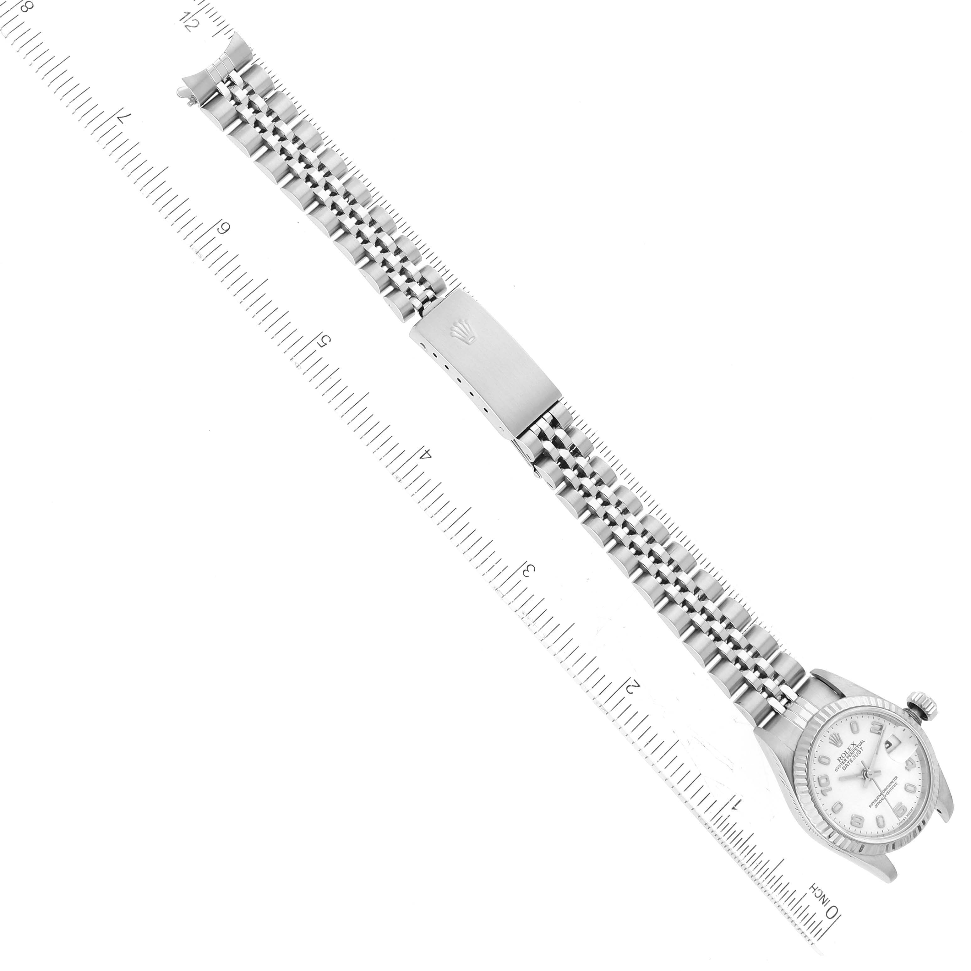 This image shows a top-down view of a Rolex Datejust 79174 Women's Stainless Steel White Dial 79174 Women's Stainless Steel White Dial watch, highlighting its face, bezel, and full bracelet with a ruler for scale.