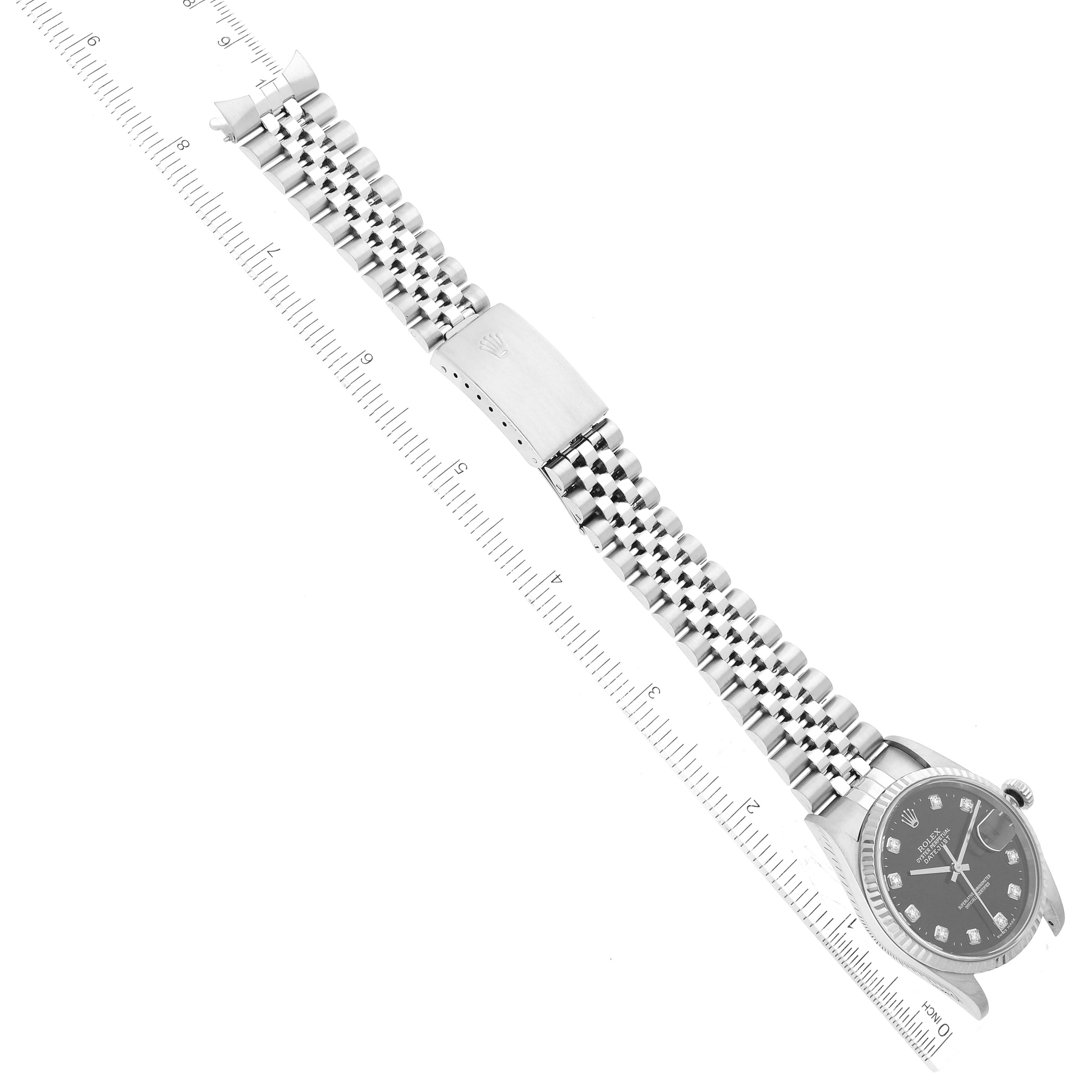 The image shows a Rolex Datejust 16234 Men's Stainless Steel Black Dial 16234 Men's Stainless Steel Black Dial watch laid flat with a visible bracelet and clasp, alongside a ruler for scale.