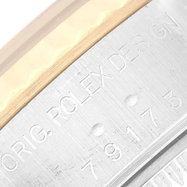 This close-up image of a Rolex Datejust 79173 Women's Steel and Gold (two tone) Black Dial 79173 Women's Steel and Gold (two tone) Black Dial watch shows the engraved serial number and "ROLEX DESIGN" text on the case.