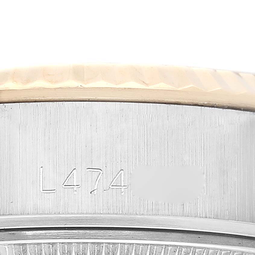 Close-up shot of the case side of a Rolex Datejust 69173 Women's Steel and Gold (two tone) Champagne Dial 69173 Women's Steel and Gold (two tone) Champagne Dial watch, showing part of the bezel and serial number engraving.
