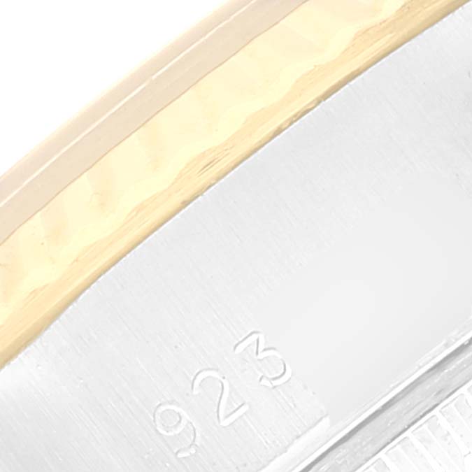 This close-up image of a Rolex Datejust 69173 Women's Steel and Gold (two tone) Champagne Dial 69173 Women's Steel and Gold (two tone) Champagne Dial watch shows a portion of the metal case and engraving.
