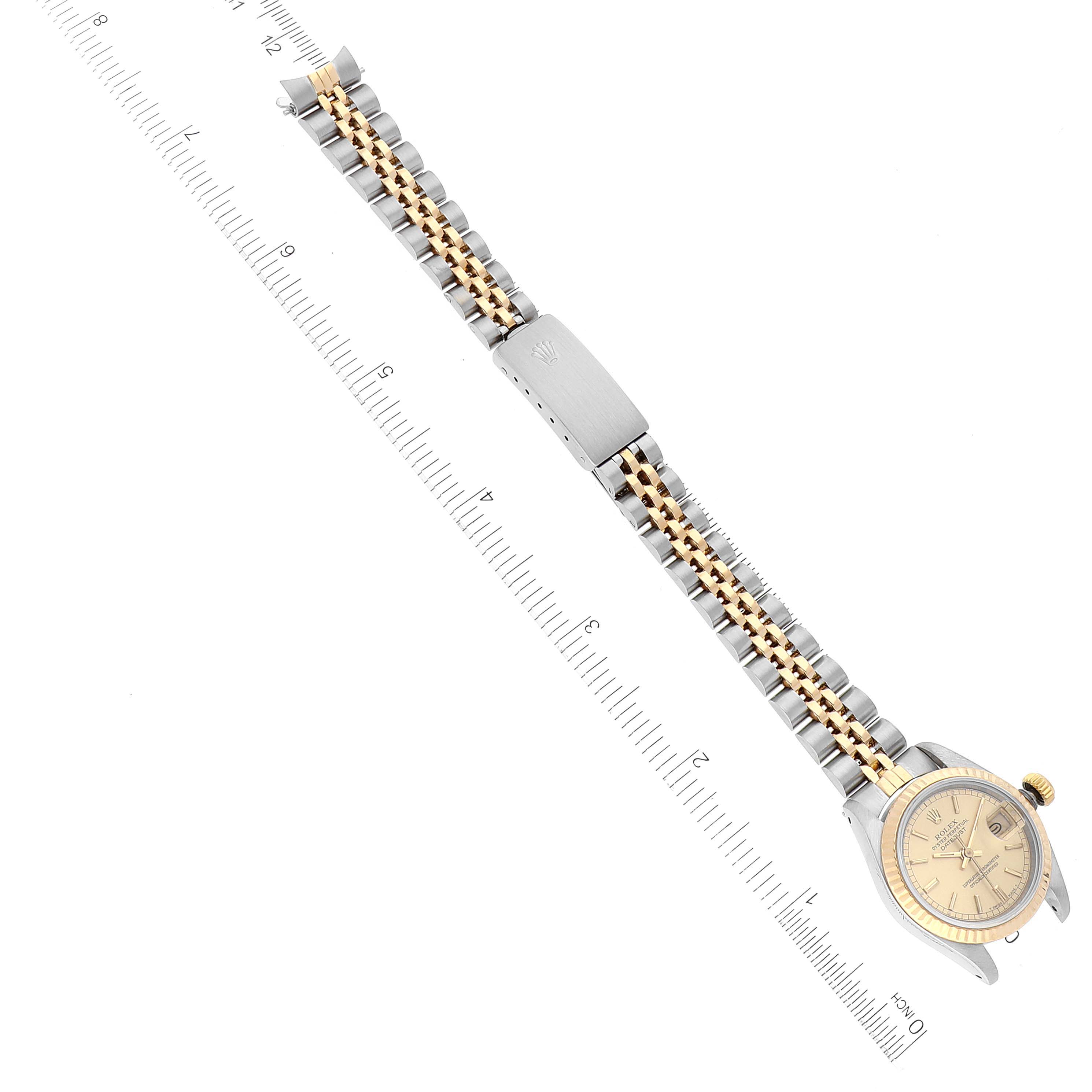The image shows a top view of a Rolex Datejust 69173 Women's Steel and Gold (two tone) Champagne Dial 69173 Women's Steel and Gold (two tone) Champagne Dial watch, highlighting its band and clasp alongside a measuring ruler.