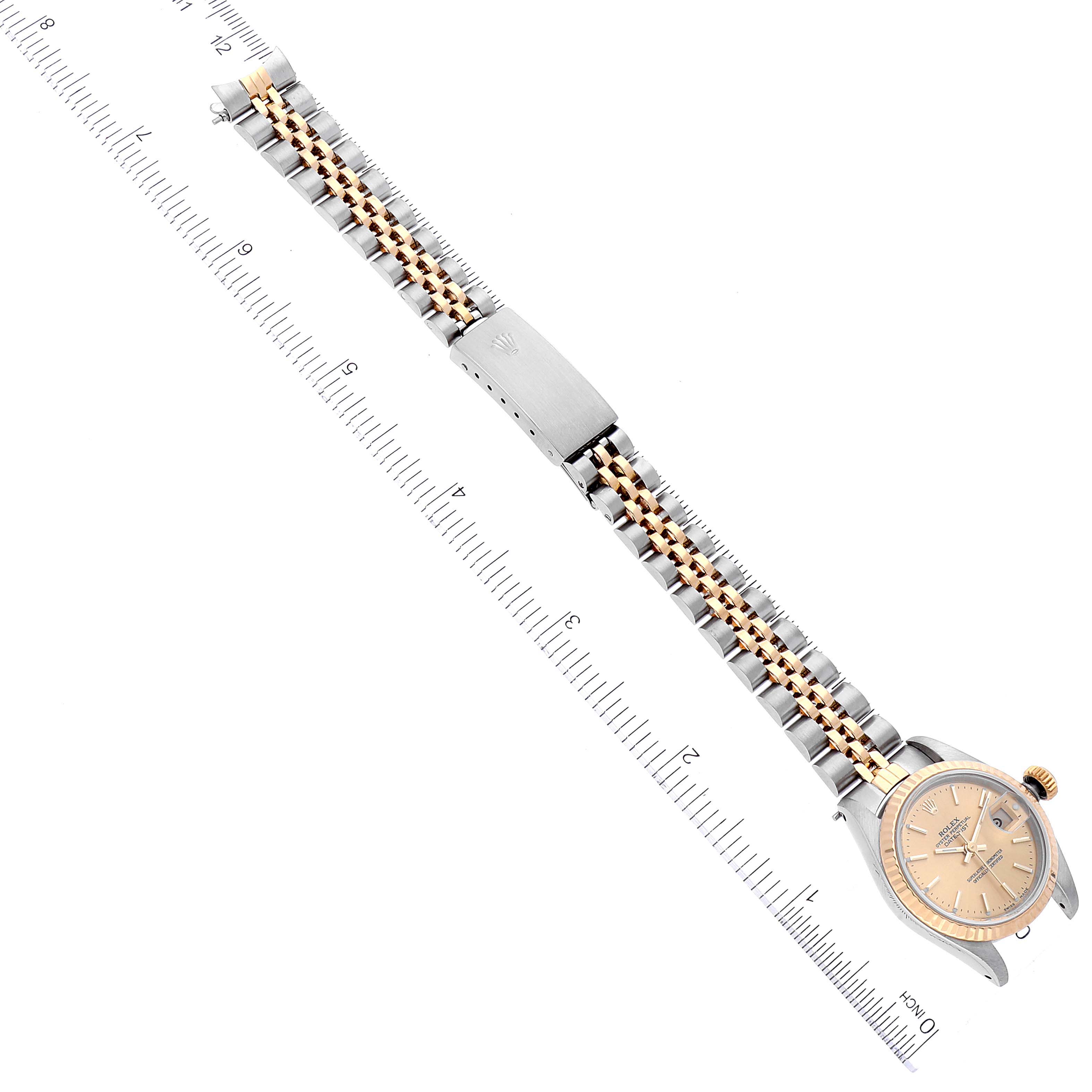 The image shows a top-down view of a Rolex Datejust 69173 Women's Steel and Gold (two tone) Champagne Dial 69173 Women's Steel and Gold (two tone) Champagne Dial watch, displaying its bracelet and face alongside a ruler for scale.