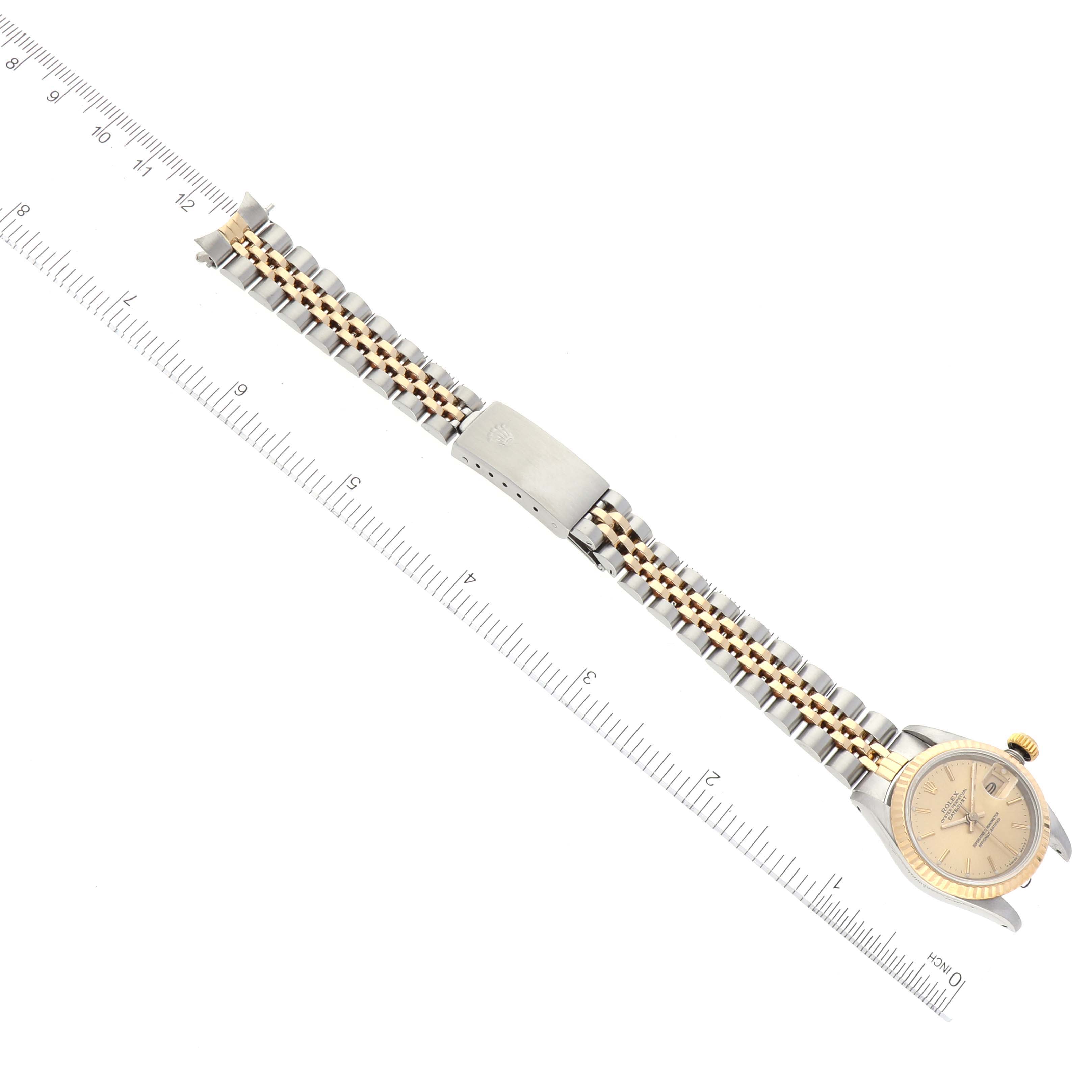 The image shows a top-down view of a Rolex Datejust 69173 Women's Steel and Gold (two tone) Champagne Dial 69173 Women's Steel and Gold (two tone) Champagne Dial watch lying flat, with the watch band, clasp, and ruler for scale.