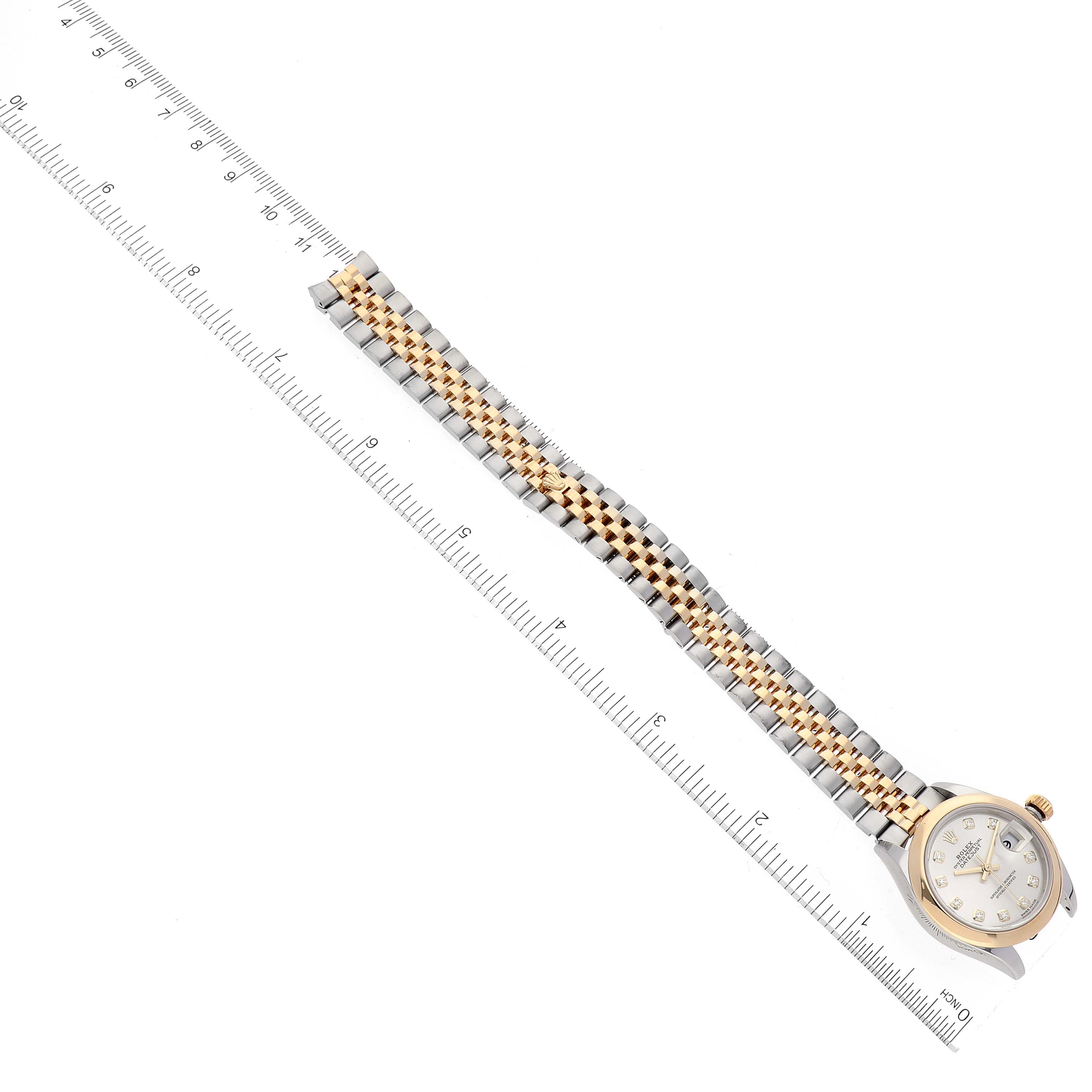 This image shows a Rolex Datejust 279163 Women's Steel and Gold (two tone) Silver Dial 279163 Women's Steel and Gold (two tone) Silver Dial watch lying flat with a two-tone bracelet next to a ruler for measurement.