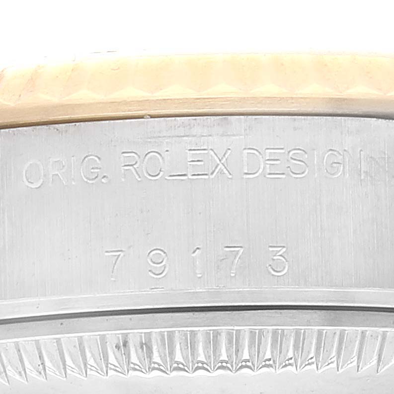 This image shows a close-up of the bezel and case side of a Rolex Datejust 79173 Women's Steel and Gold (two tone) White Dial 79173 Women's Steel and Gold (two tone) White Dial watch, displaying the engraved text and model number.