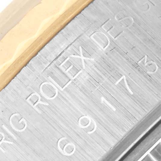 The image shows an up-close angle of the Rolex Datejust 69173 Women's Steel and Gold (two tone) White Dial 69173 Women's Steel and Gold (two tone) White Dial model's inner bezel with engraved text.