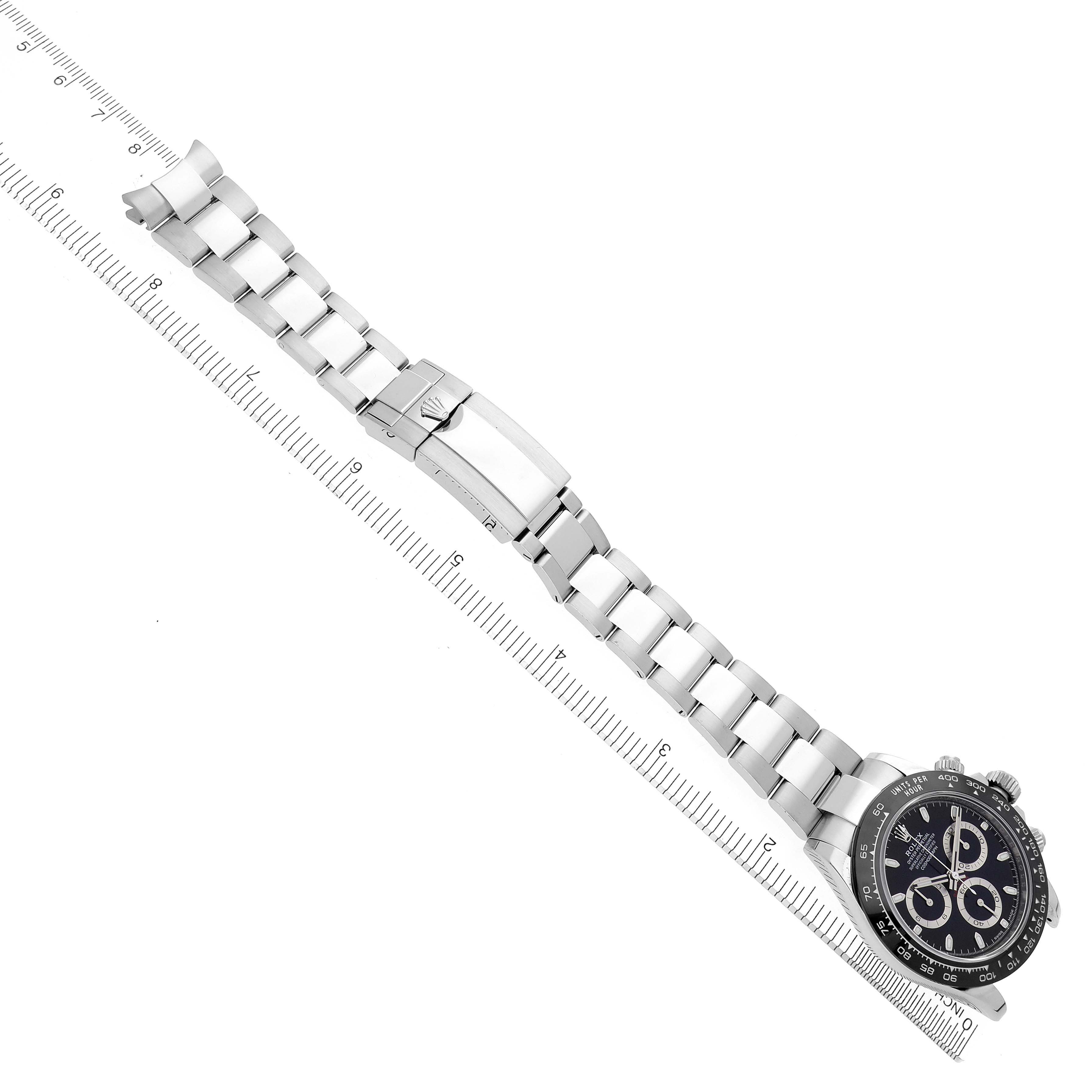 The Rolex Daytona 116500 Men's Stainless Steel Black Dial 116500 Men's Stainless Steel Black Dial watch is shown with a full view of the bracelet and clasp, aligned with a ruler for scale.