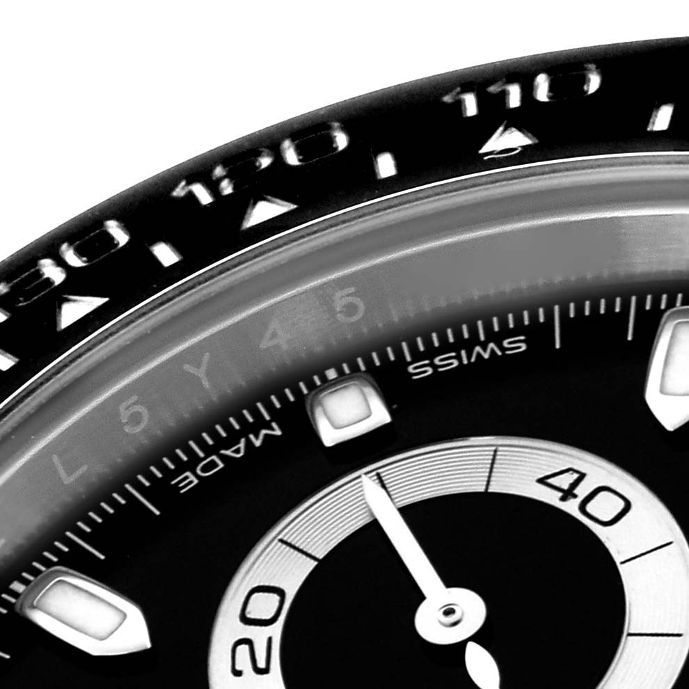 The image shows a close-up of the Rolex Daytona 116500 Men's Stainless Steel Black Dial 116500 Men's Stainless Steel Black Dial watch face, highlighting the bezel and part of the dial.