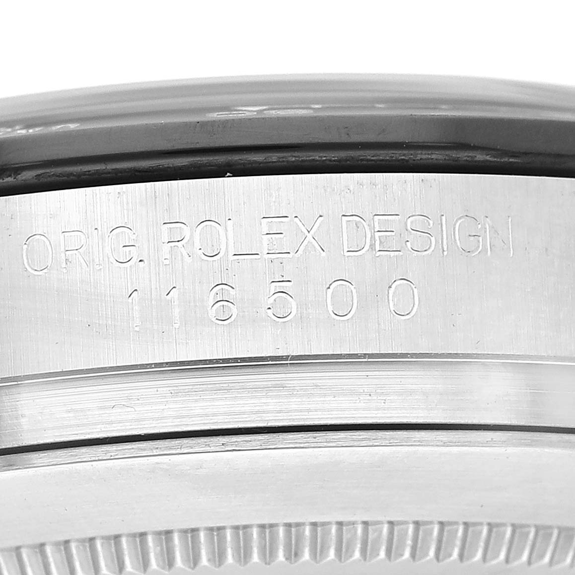 The image shows a close-up of the side of a Rolex Daytona 116500 Men's Stainless Steel White Dial 116500 Men's Stainless Steel White Dial watch with the engraving "ORIG. ROLEX DESIGN 116500."