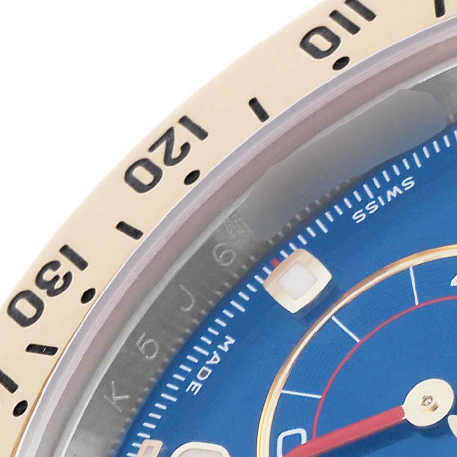 The image shows a close-up of the bezel and part of the dial of a Rolex Daytona 116523 Men's Steel and Gold (two tone) Blue Dial 116523 Men's Steel and Gold (two tone) Blue Dial watch.