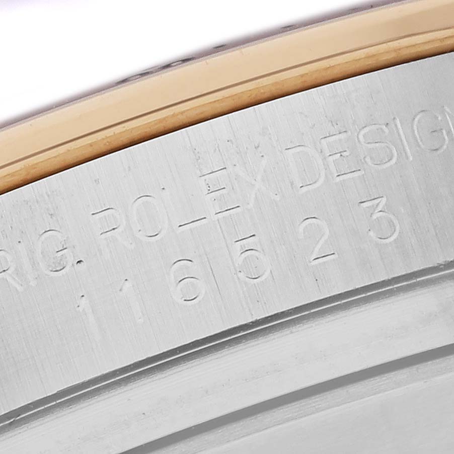The image shows the serial number engraving on the side of a Rolex Daytona 116523 Men's Steel and Gold (two tone) Blue Dial 116523 Men's Steel and Gold (two tone) Blue Dial watch case.