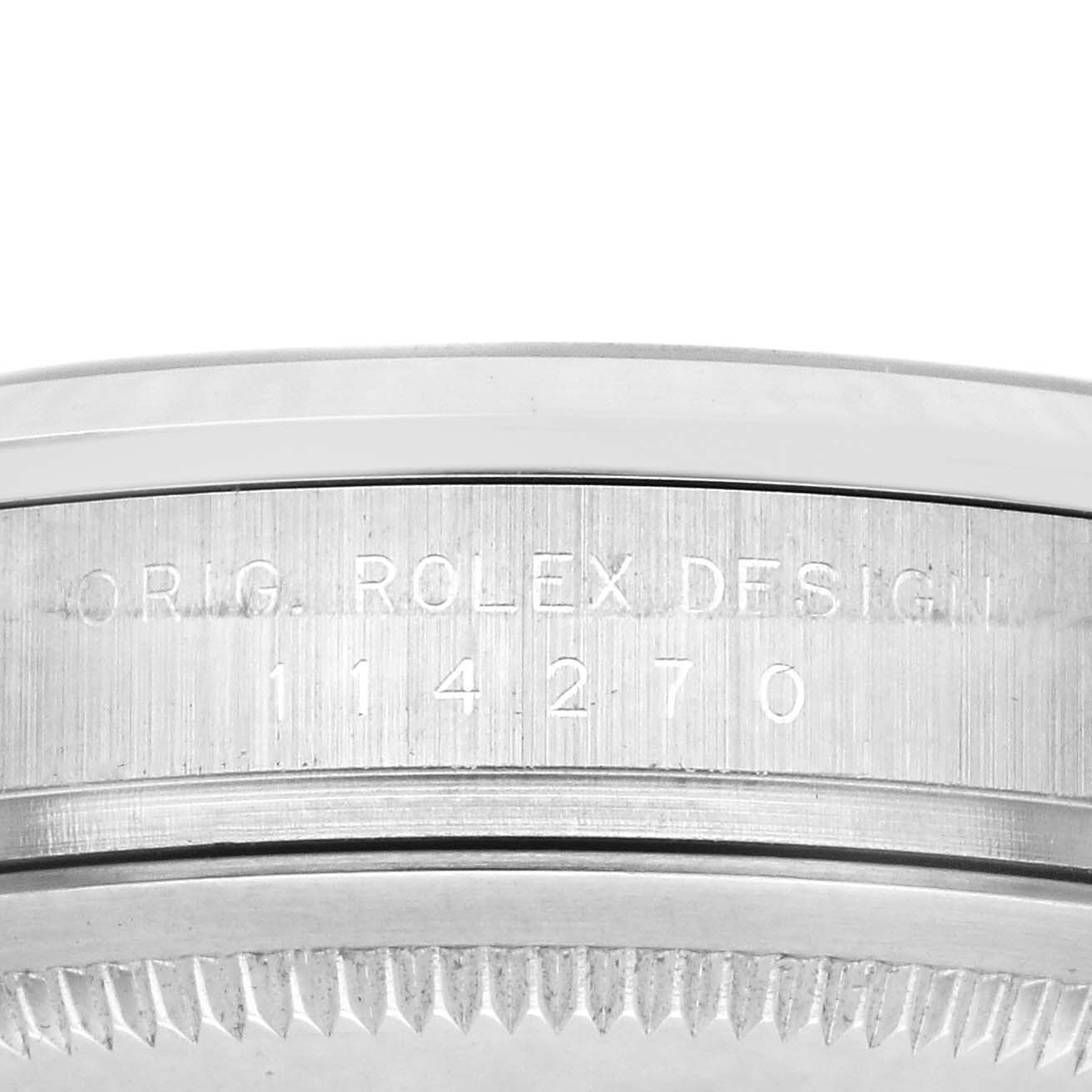 The image shows a detailed side view of the Rolex Explorer 114270 Men
s Stainless Steel Black Dial 114270 Men
s Stainless Steel Black Dial
s case edge with the "ORIG ROLEX DESIGN" engraving and model number.