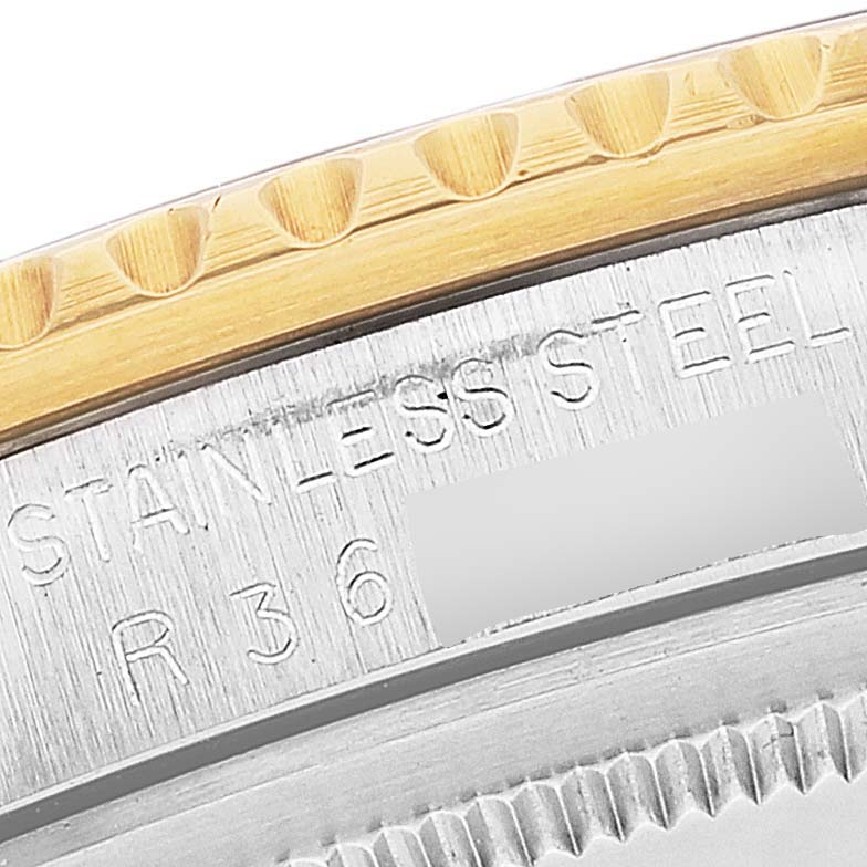 This image shows a macro shot of the bezel and case side of a Rolex GMT-Master 16753 Men's Steel and Gold (two tone) Black Dial 16753 Men's Steel and Gold (two tone) Black Dial watch, highlighting the "STAINLESS STEEL" engraving.