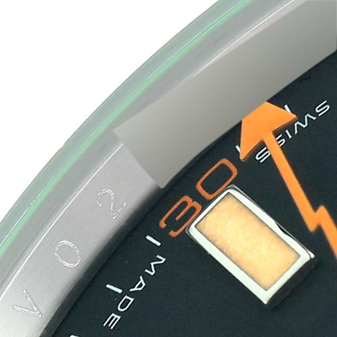 The image shows a close-up of the dial and bezel of a Rolex Milgauss 116400 Men's Stainless Steel Black Dial 116400 Men's Stainless Steel Black Dial watch, focusing on the 30-minute mark and the orange lightning bolt hand.