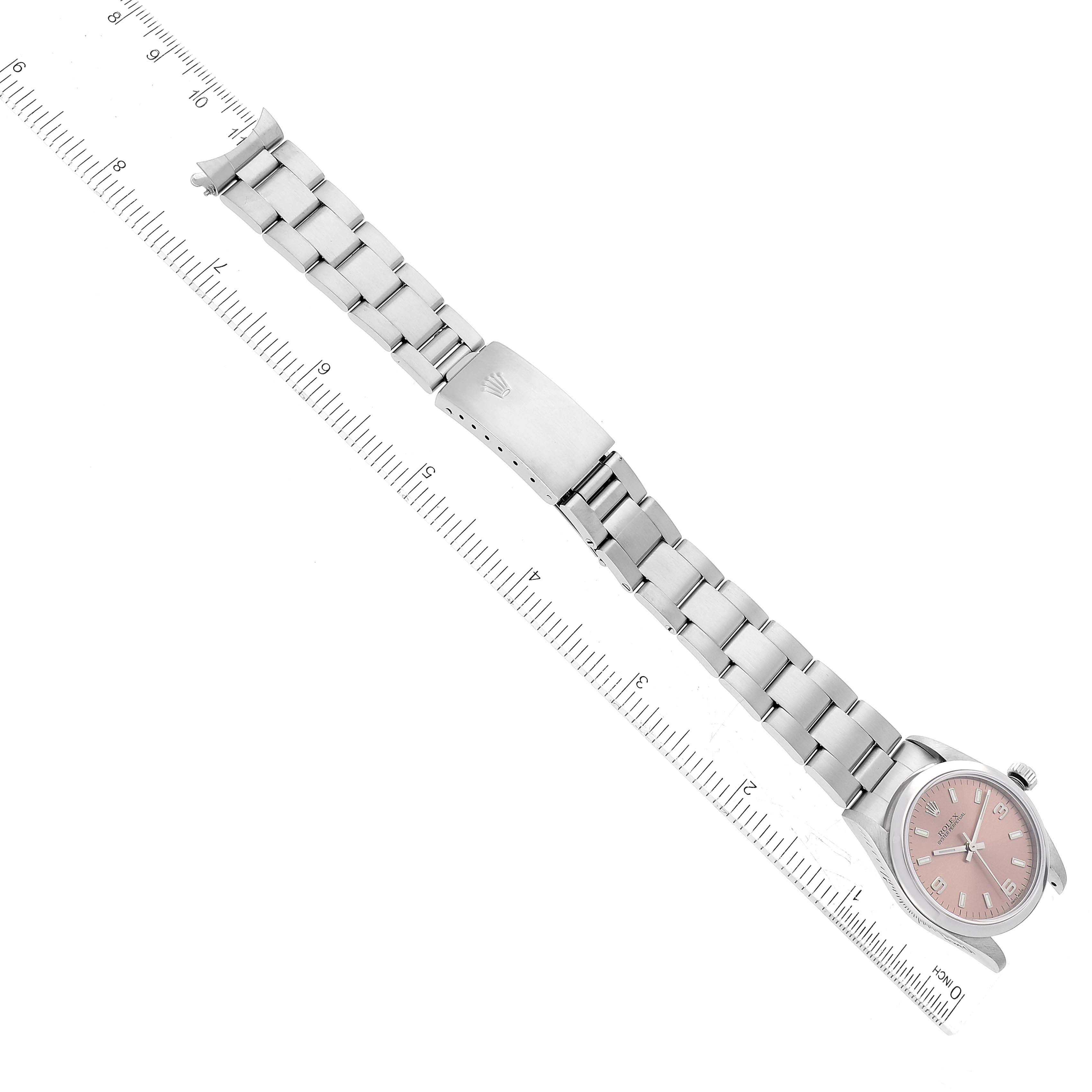 The image shows a Rolex Mid-Size 77080 Women's Stainless Steel Pink Dial 77080 Women's Stainless Steel Pink Dial watch with a pink dial, viewed from the top alongside a measuring ruler.