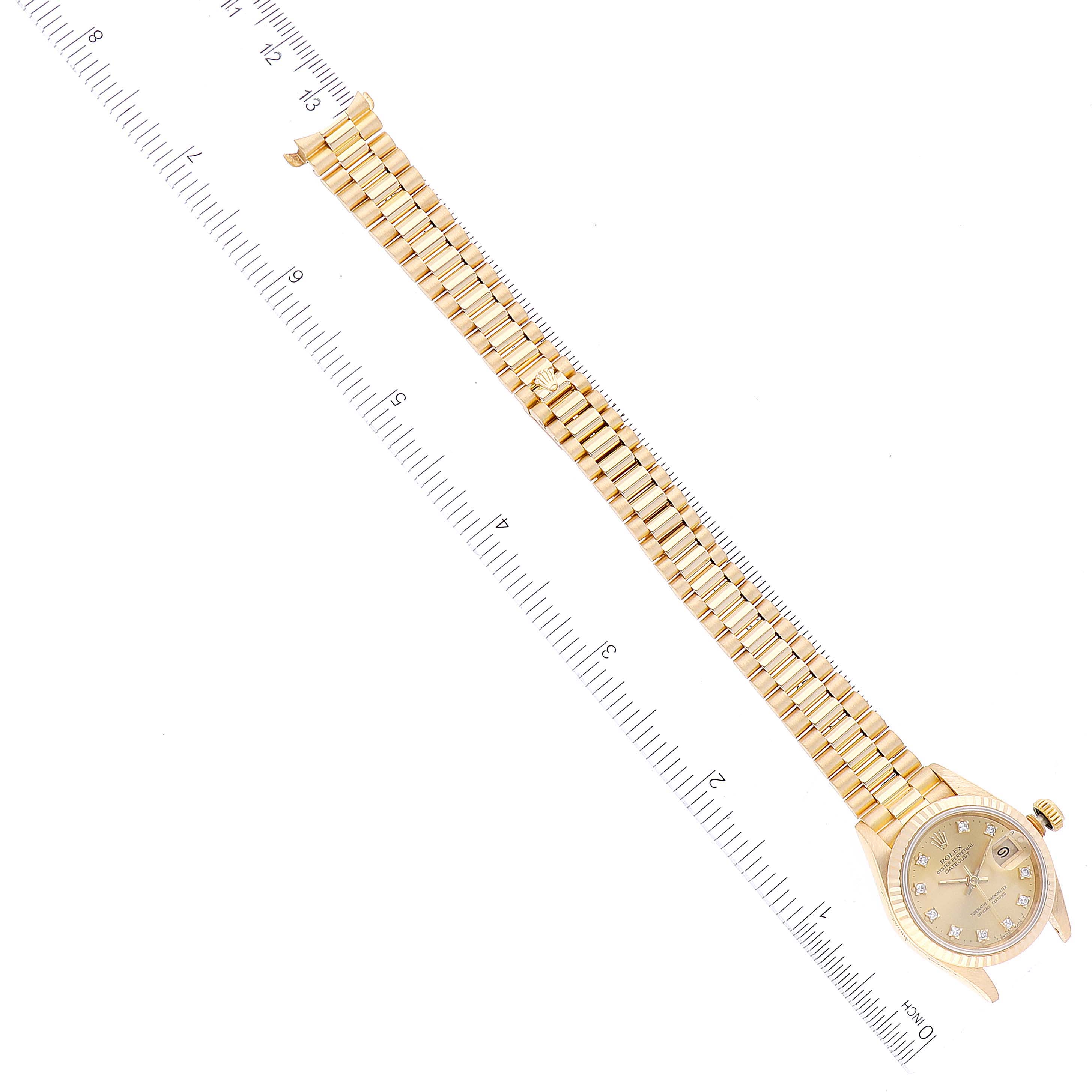 The image shows an overhead view of a Rolex President 69178 Women
s Yellow Gold Champagne Dial 69178 Women
s Yellow Gold Champagne Dial watch, displaying the dial and full bracelet with a ruler for scale.