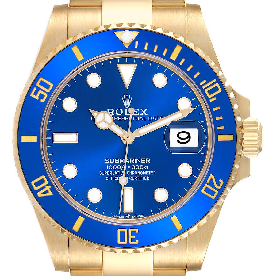 The image shows a front view of the Rolex Submariner watch, highlighting the blue dial, gold case, and bezel.