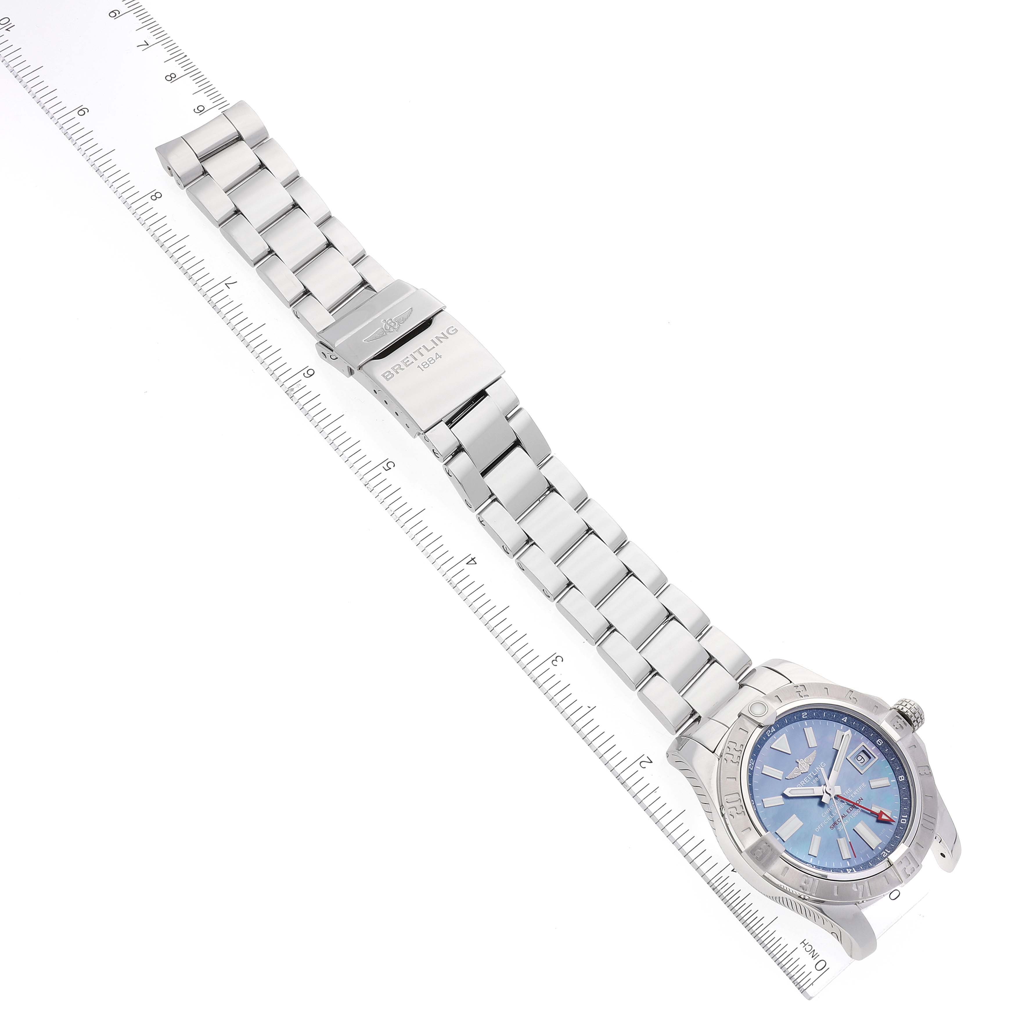 The image shows a Breitling Avenger A3239011-C872-170A Men's Stainless Steel Mother of Pearl Dial A3239011-C872-170A Men's Stainless Steel Mother of Pearl Dial model watch with its full metal bracelet and blue dial, placed next to a measuring scale.